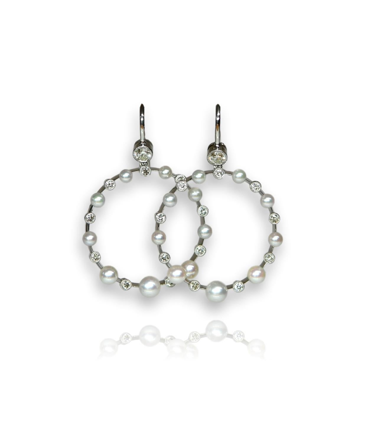These pretty and elegant earrings were made using an Edwardian design. Each earring has a hoop decorated with nine diamonds and nine pearls. There is such attention to detail in the setting of the diamonds, with each surrounded by a millegrain