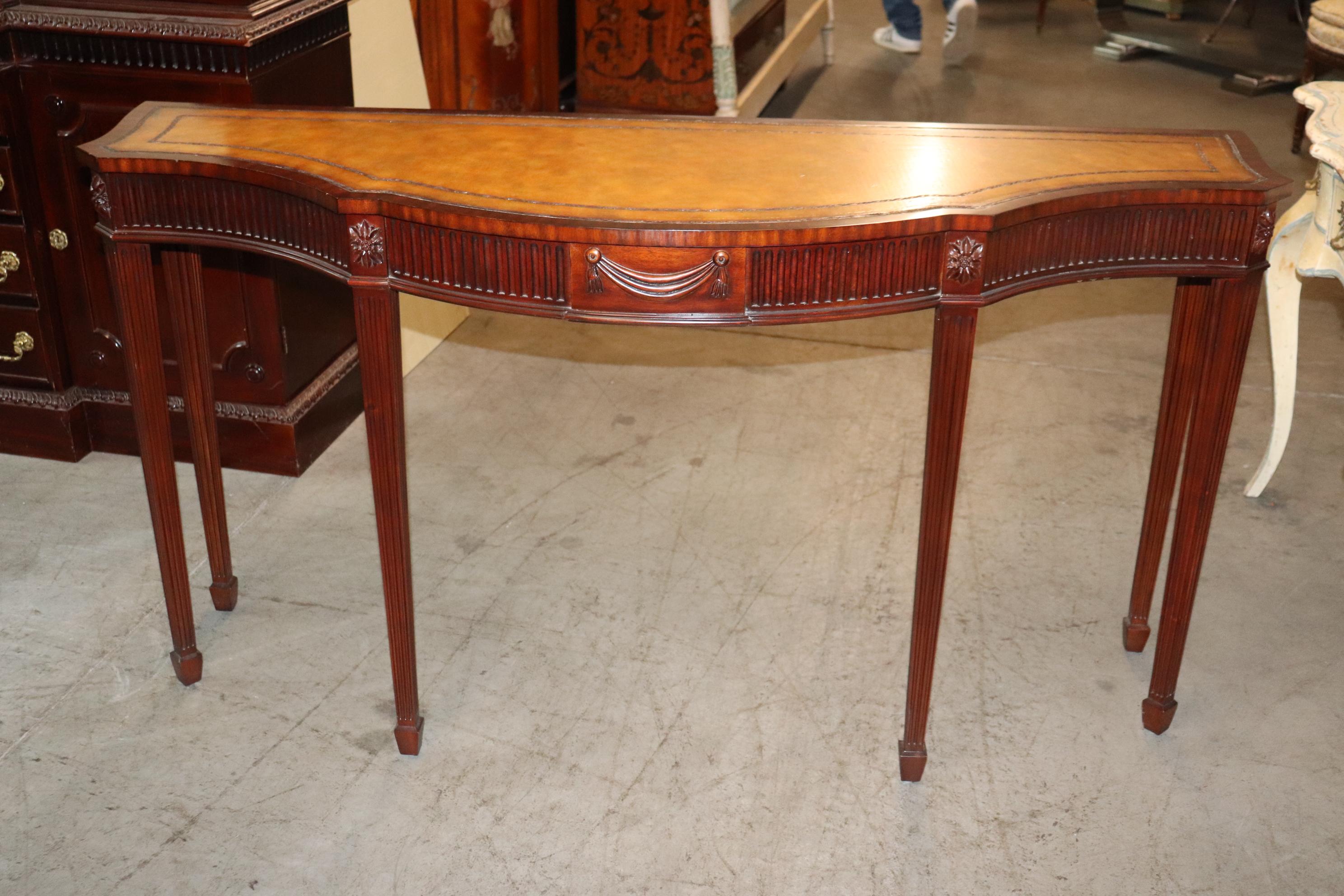 This is a superb Maitland Smith Leather top console table with a solid mahogany frame in very good vintage condition dating to teh 1990-2000s era. The table is beautifully carved and the leather top is in very good condition and needs nothing to be