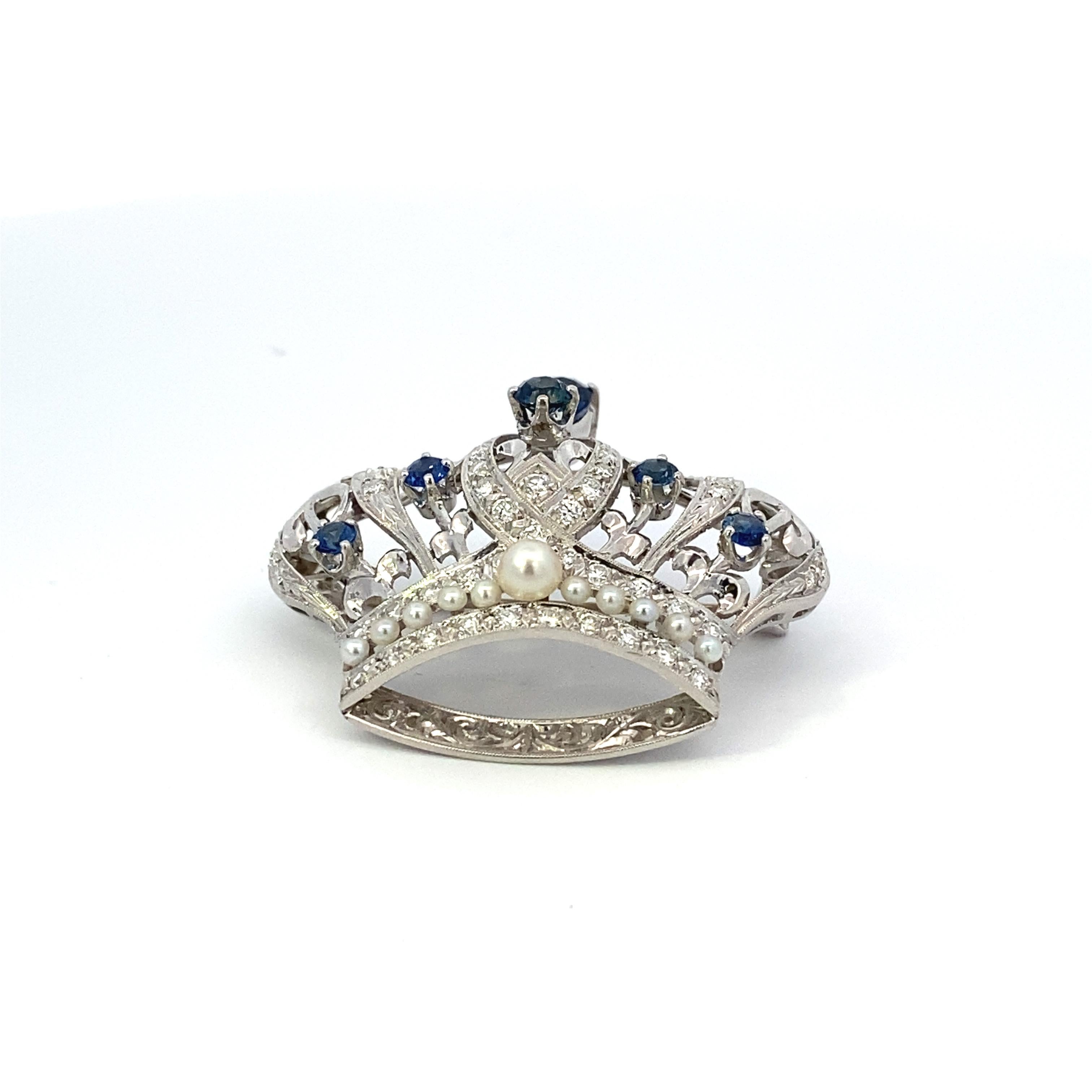 Edwardian-Styled platinum crown brooch with .73 carat pear-cut sapphire, 5 = .84 carat total weight round sapphires, .96 carat total weight F+ VS diamonds and 11 = AAA grade 2-4mm pearls. 40 mm wide x 35 mm high. Safety on pin.