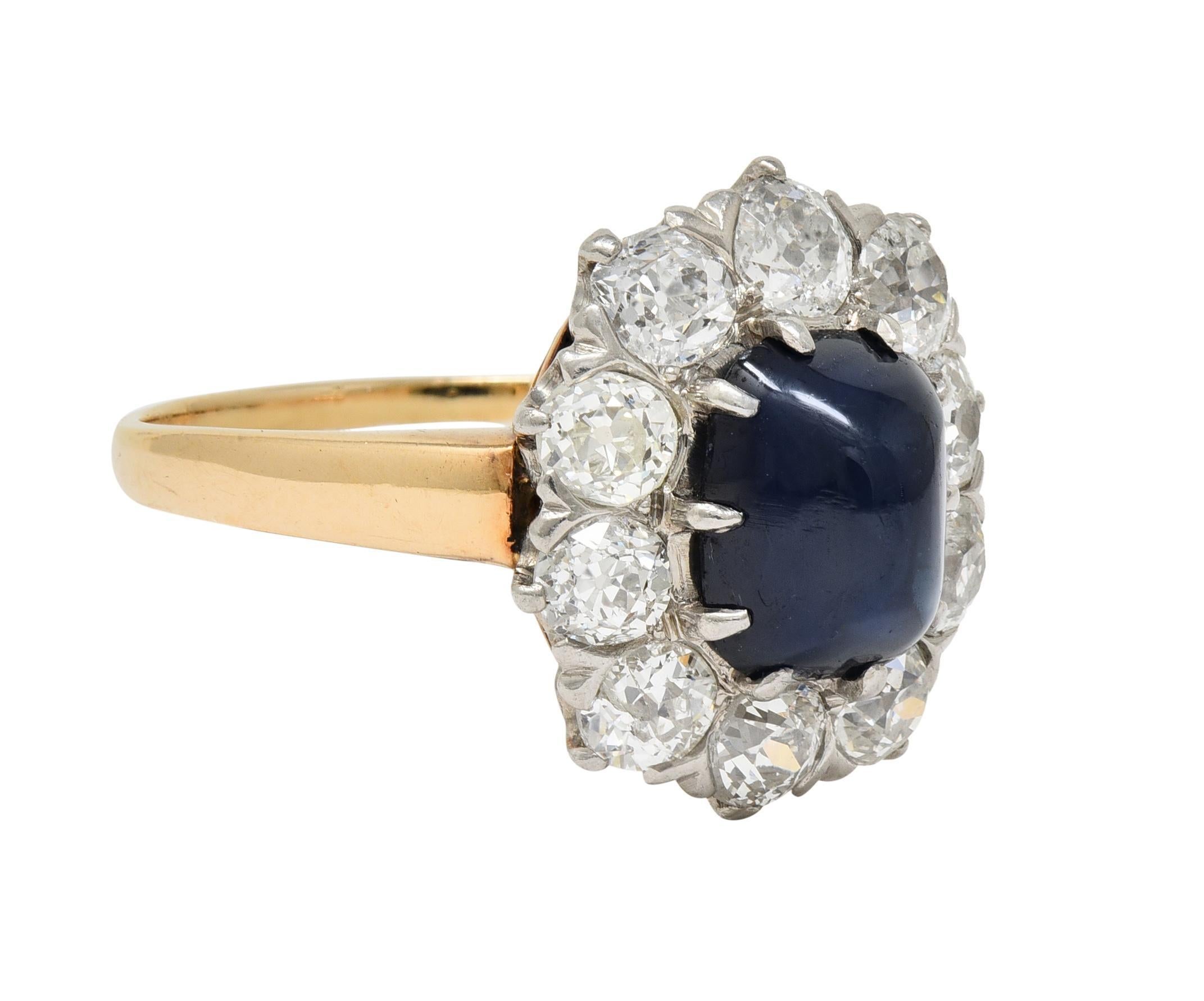 Centering a sugarloaf-shaped sapphire cabochon weighing approximately 2.30 carats total
Natural Cambodian in origin with no indications of heat treatment - transparent dark blue
Set with talon prongs in platinum-topped head with diamond halo