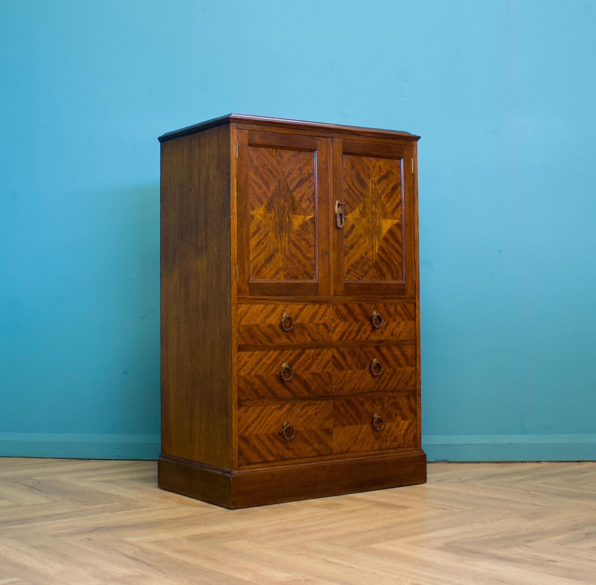 Un impresionante tallboy o armario de ama de llaves de caoba con incrustaciones de calidad, hacia la década de 1910


Internamente hay una estantería y tres cajones en el exterior


La llave original está presente y la cerradura funciona - las