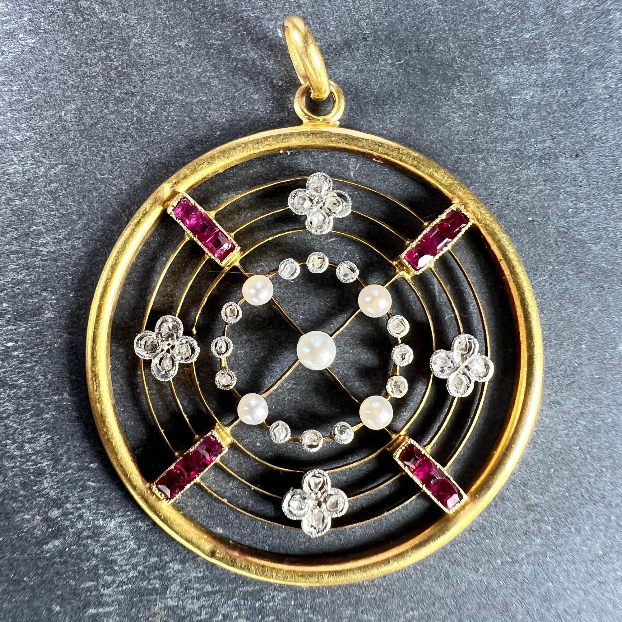 An Edwardian 18 karat (18K) yellow gold pendant designed as a circle with wirework gold crossed lines set with panels of square-cut rubies leading to a natural pearl at the centre. The innermost circle set with four seed pearls each separated by