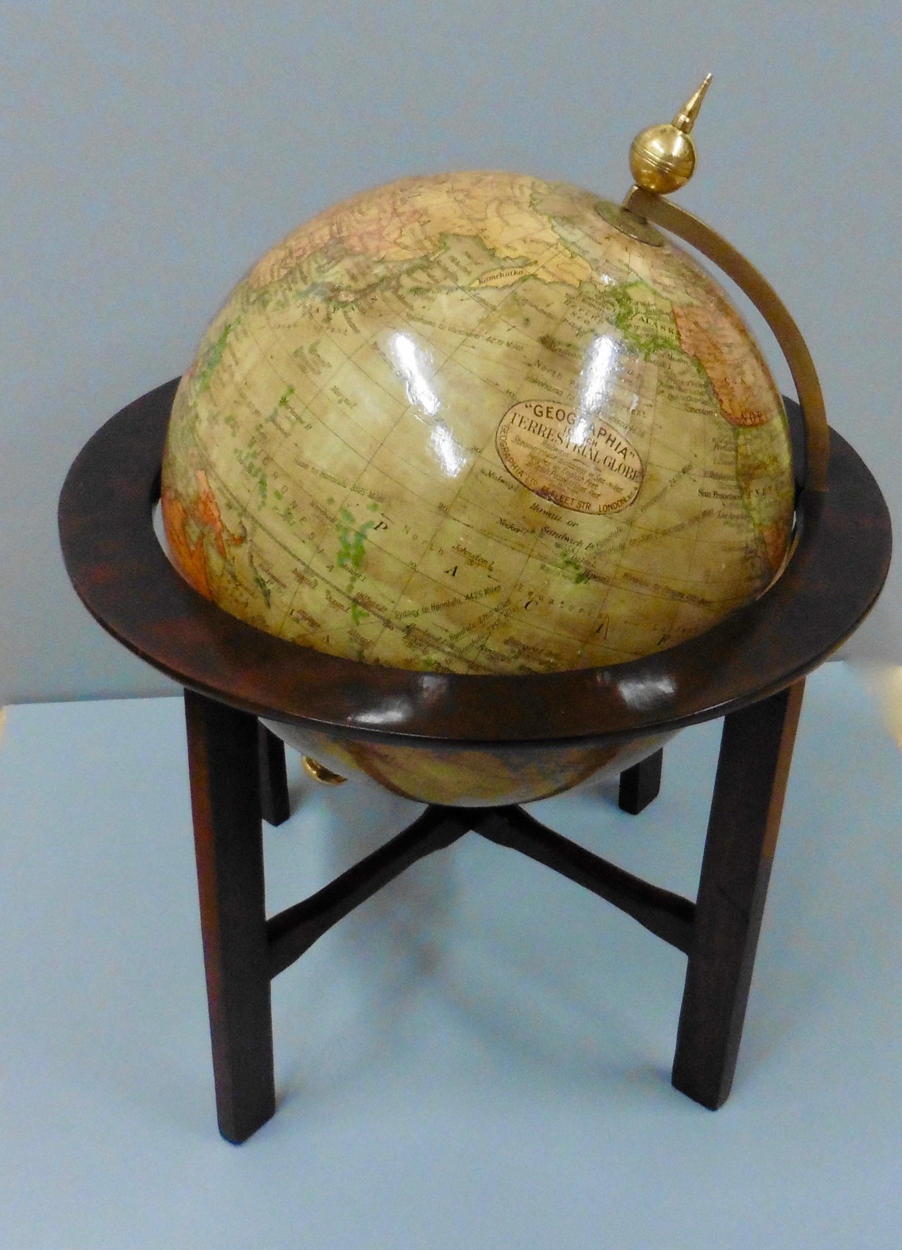 Edwardian terrestrial Geographia tabletop globe.

Edwardian terrestrial Geographia 10 inch tabletop globe standing on a raised stained mahogany stand.

This globe is complete with it’s original colored paper gores, brass half meridian surmounted