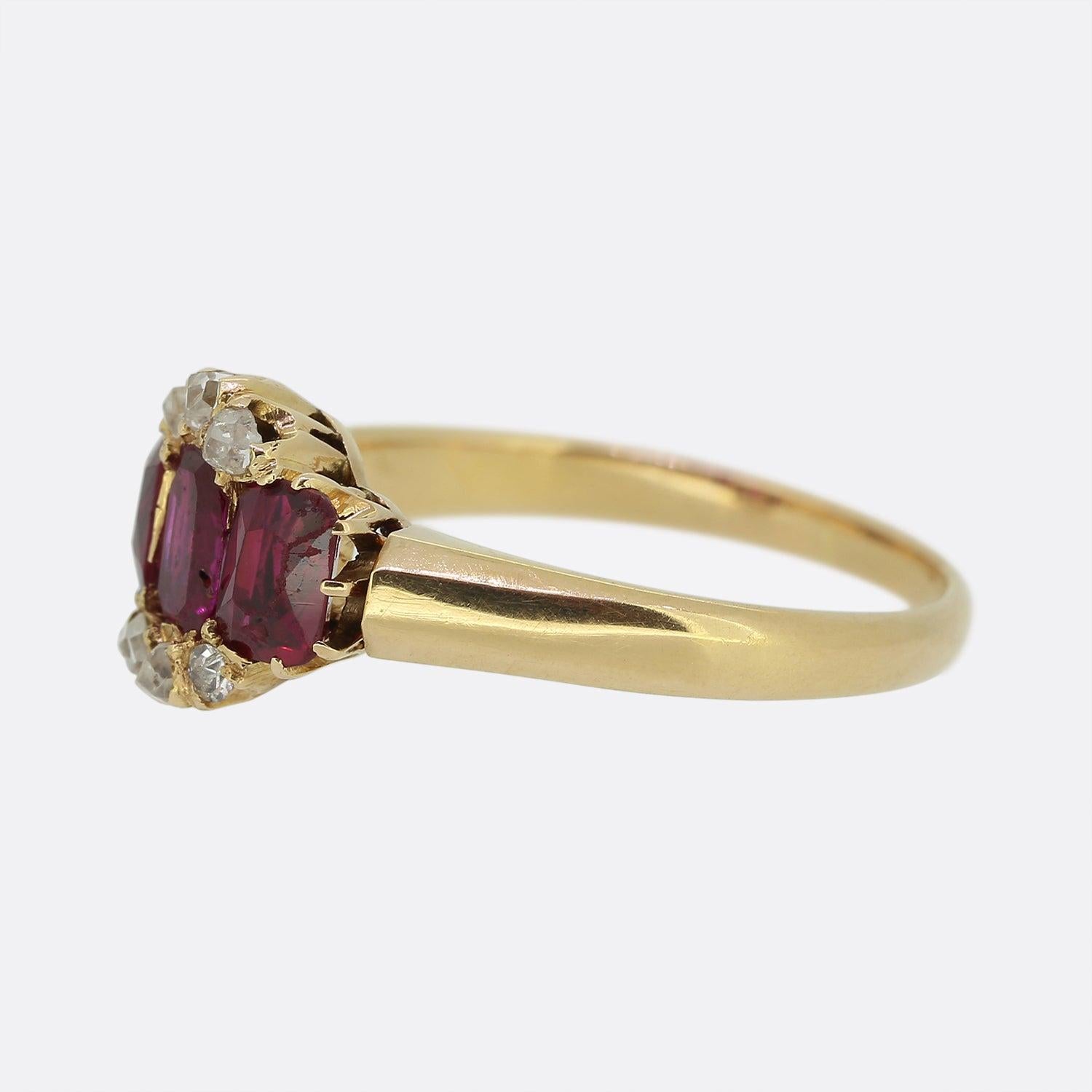 Aquí tenemos un encantador anillo antiguo de rubíes y diamantes que data de la época eduardiana. Un trío de rubíes rojos facetados ovalados, con un ligero matiz rosado, se sitúan uno junto al otro en el centro de la cara. Estas piedras principales