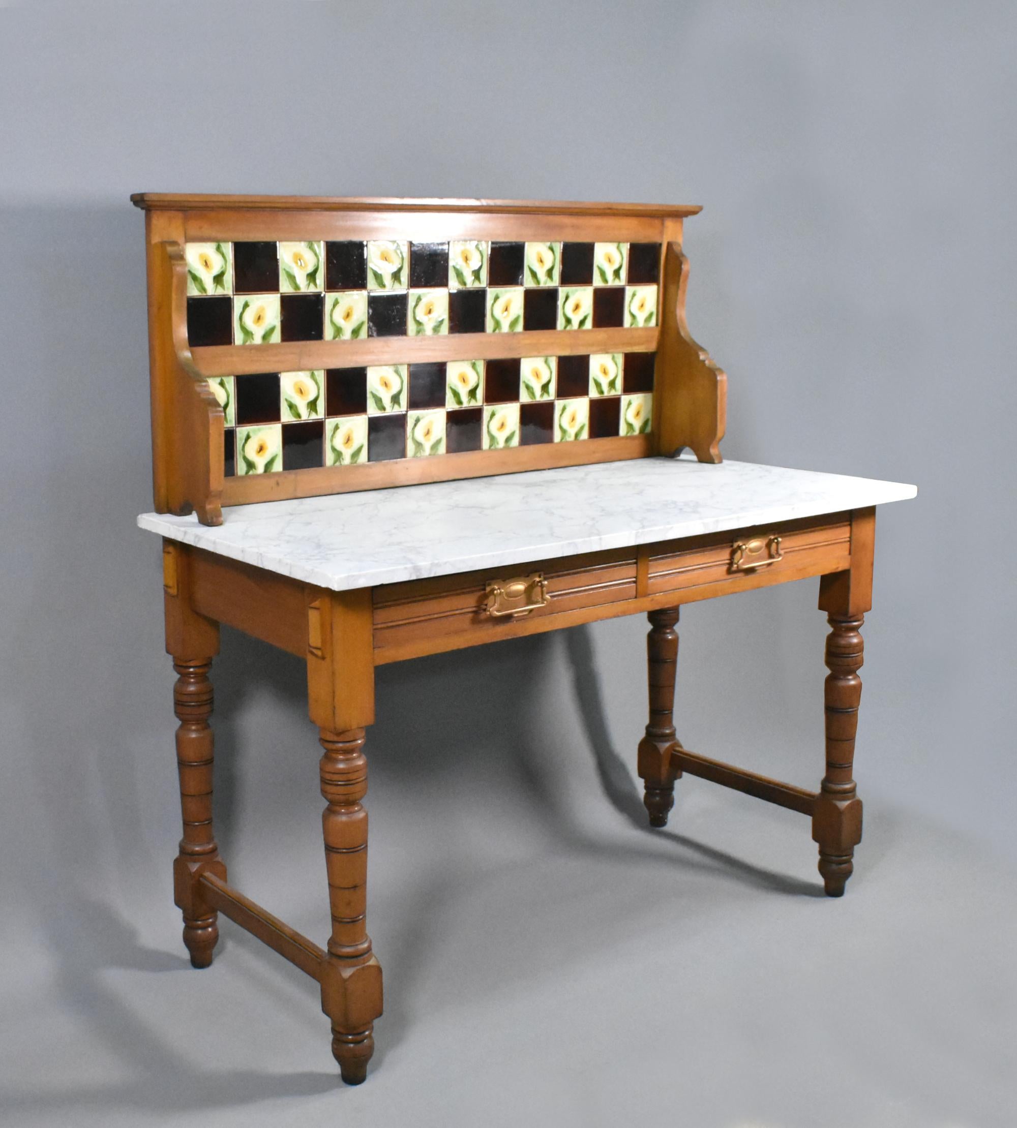 Edwardian Tile Back Marble Top Washstand in Birch
 
This attractive washstand features a chequered tiled splash back, decorated with arum lilies and contrasting deep brown squares, all captivated within a wooden frame.
 
The back splash sits on a
