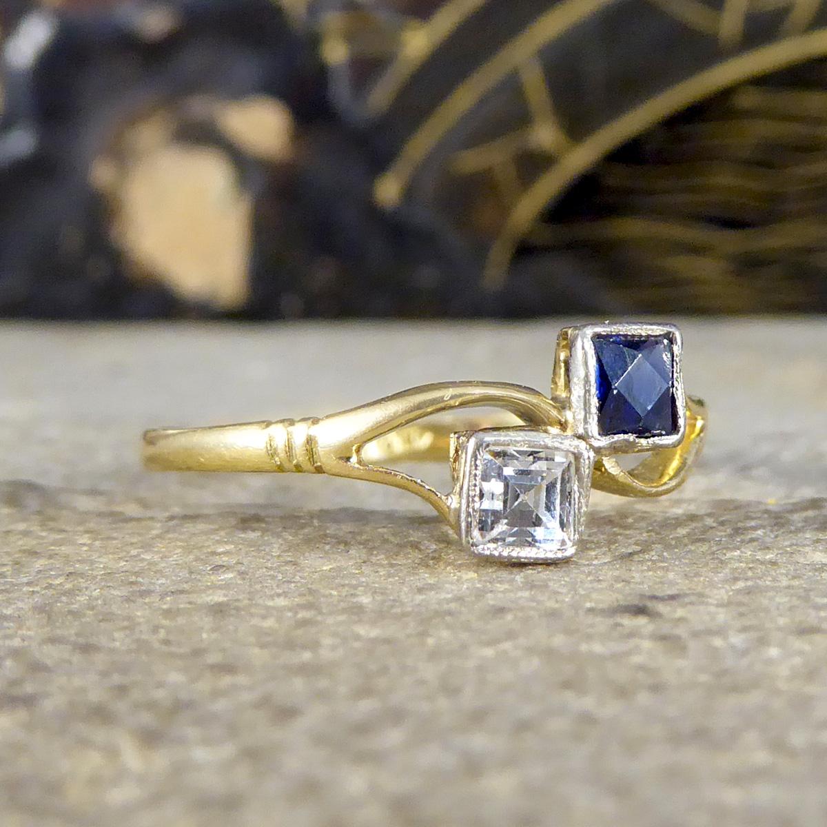 A very elegant two stone Sapphire twist ring that is set with two sparkling Sapphires of different colours. One is blue in colour and the other is colourless weighing a total of 0.42ct. The stones are set in a bezel settings in a Toi et Moi style.