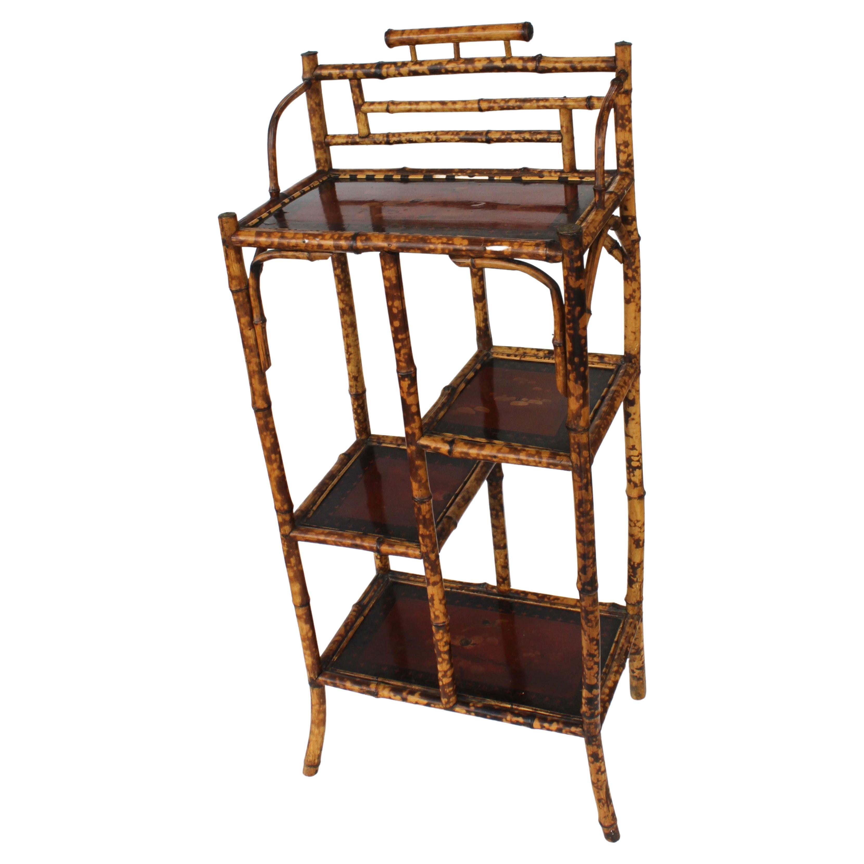 This stylish and chic Edwardian period etagere dates to the 1880s-1910s and is in the Japonais style, with its tortoise bamboo and lacquered panels detailed with blooming cherry trees and exotic birds.