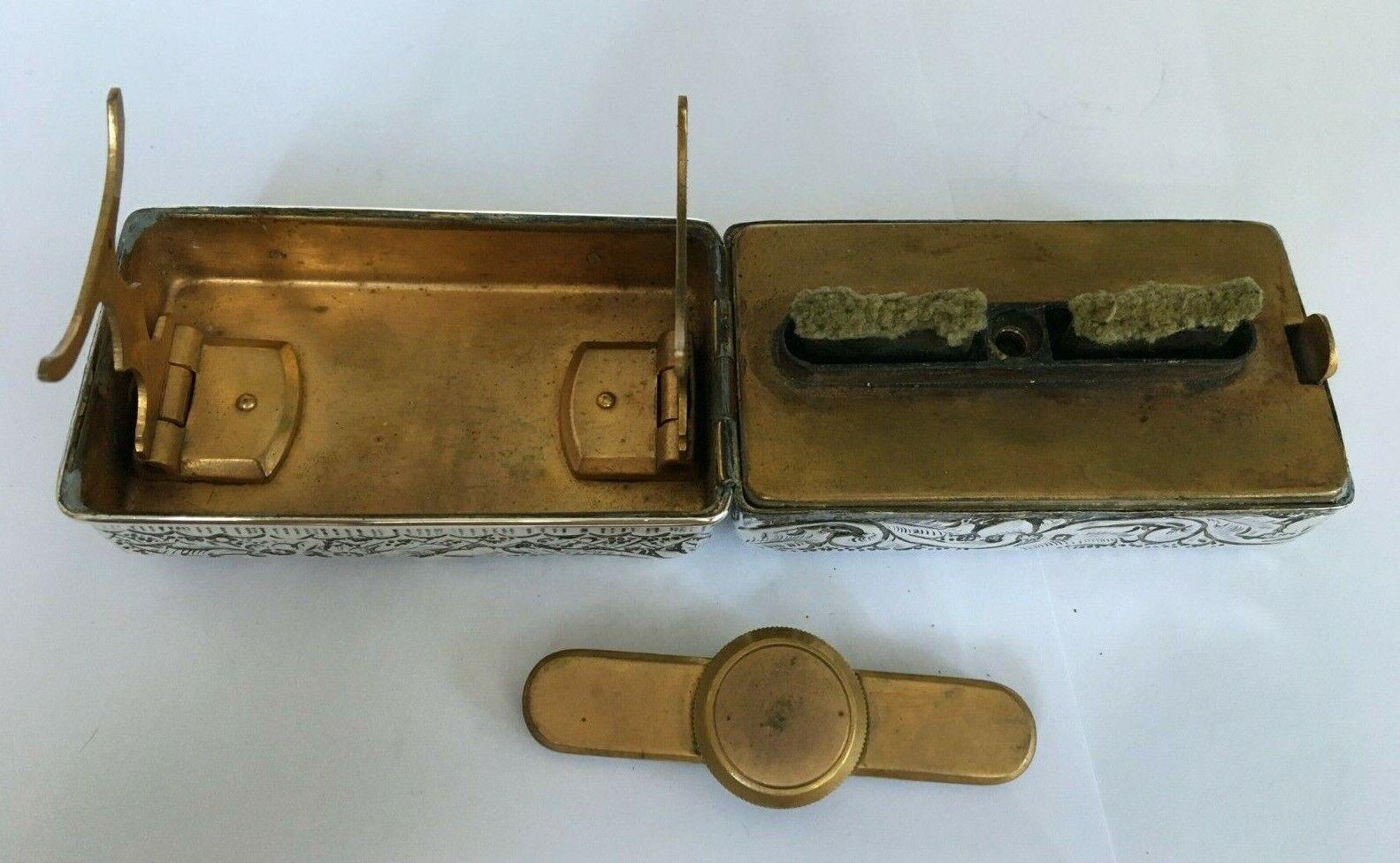 Edwardian Travelling Curling Tong Heater by A & J Zimmermann Ltd in 1903

This unusual piece is in excellent condition. This silver cased portable curling tong heater is of rectangular form.
The outer case is embossed with floral scrolling, the
