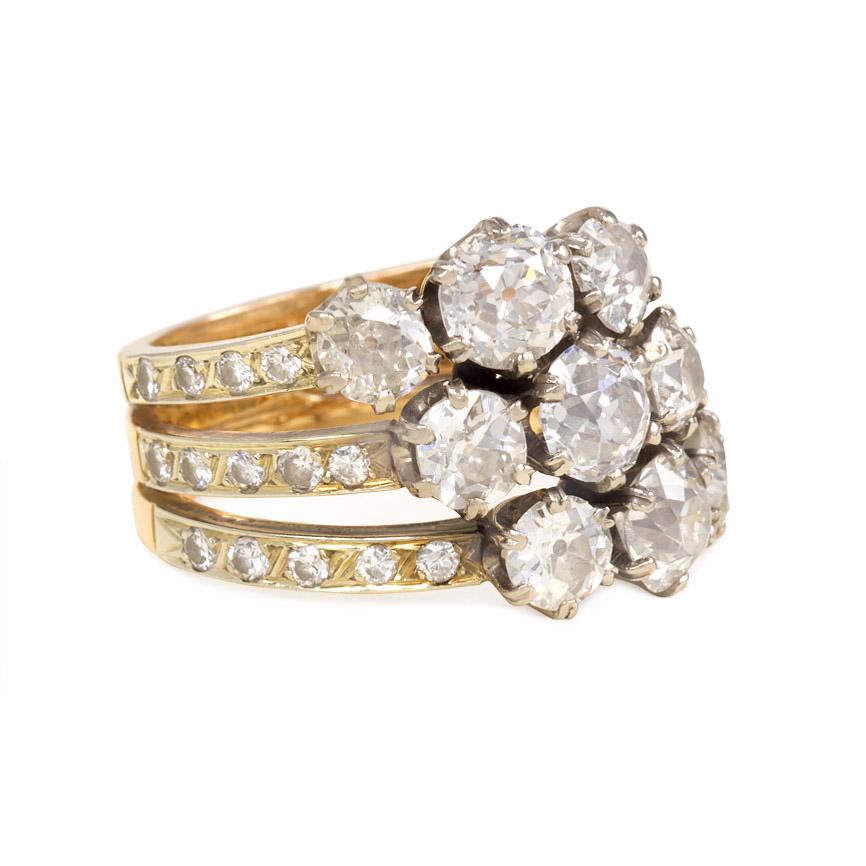 An antique Edwardian period diamond harem ring comprised of three bands, each set with three old European cut diamonds and single cut diamond accents, in platinum and 18K gold.  Atw. 4.16 ct. diamonds.  French import

Current ring size: US 6 1/2