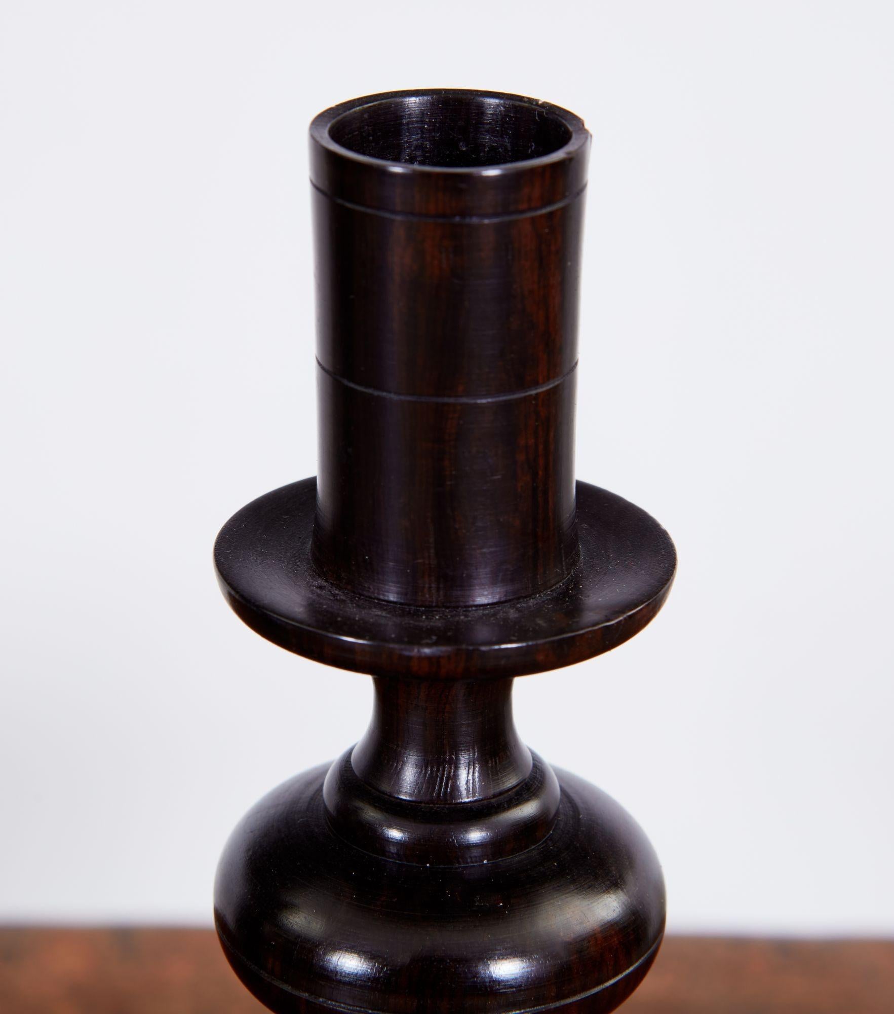 Fine pair of solid ebony lathe-turned candlesticks with ribbed shafts and standing on turned plinth bases.
 
Treen