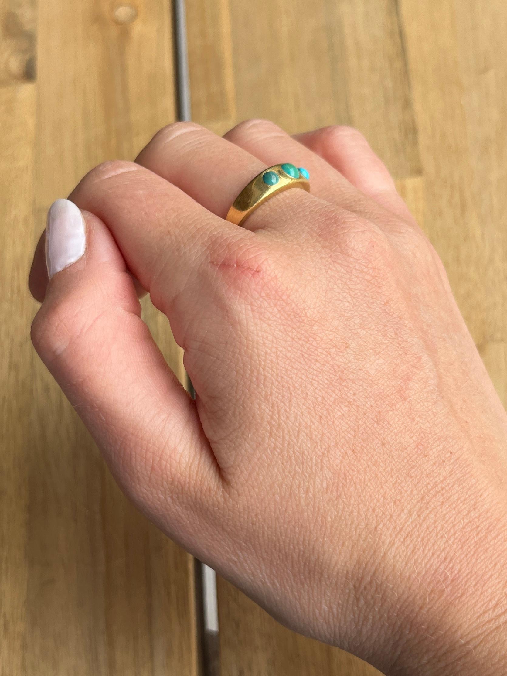 This glossy 18ct gold band holds a beautifully bright natural turquoise cabochon stones. The stones are bright and beautiful and complimented by the yellow gold perfectly. 

Ring Size: M 1/2 or 6 1/2 
Band Width: 5.5mm

Weight: 5.3g