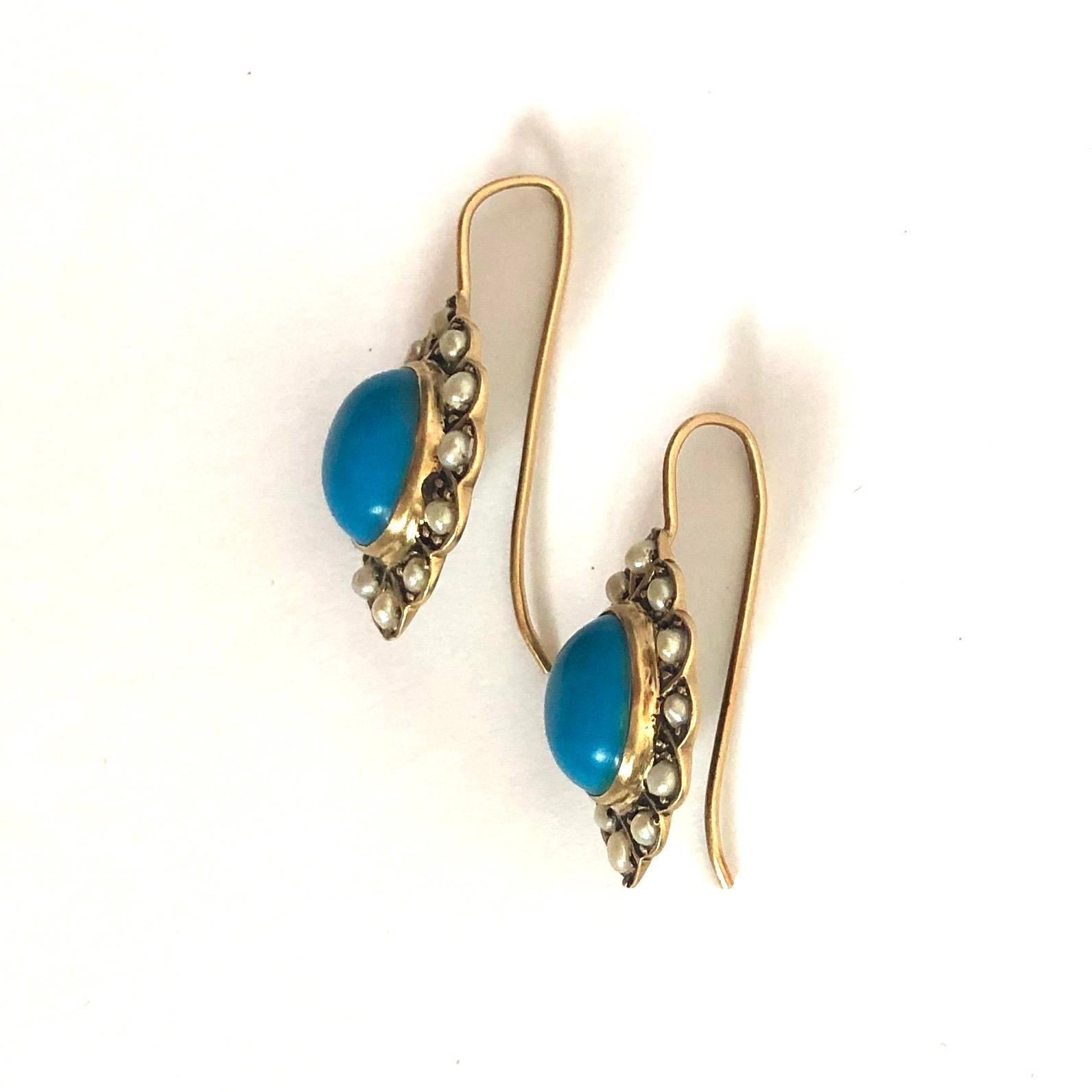 The bright blue turquoise stones are surrounded by a border of pearls and are set in 9ct gold. The face of the earrings are attached to shepherd hooks. 

Face Dimension: 19x14mm 
Drop From Ear: 26mm 

Weight: 3.56g