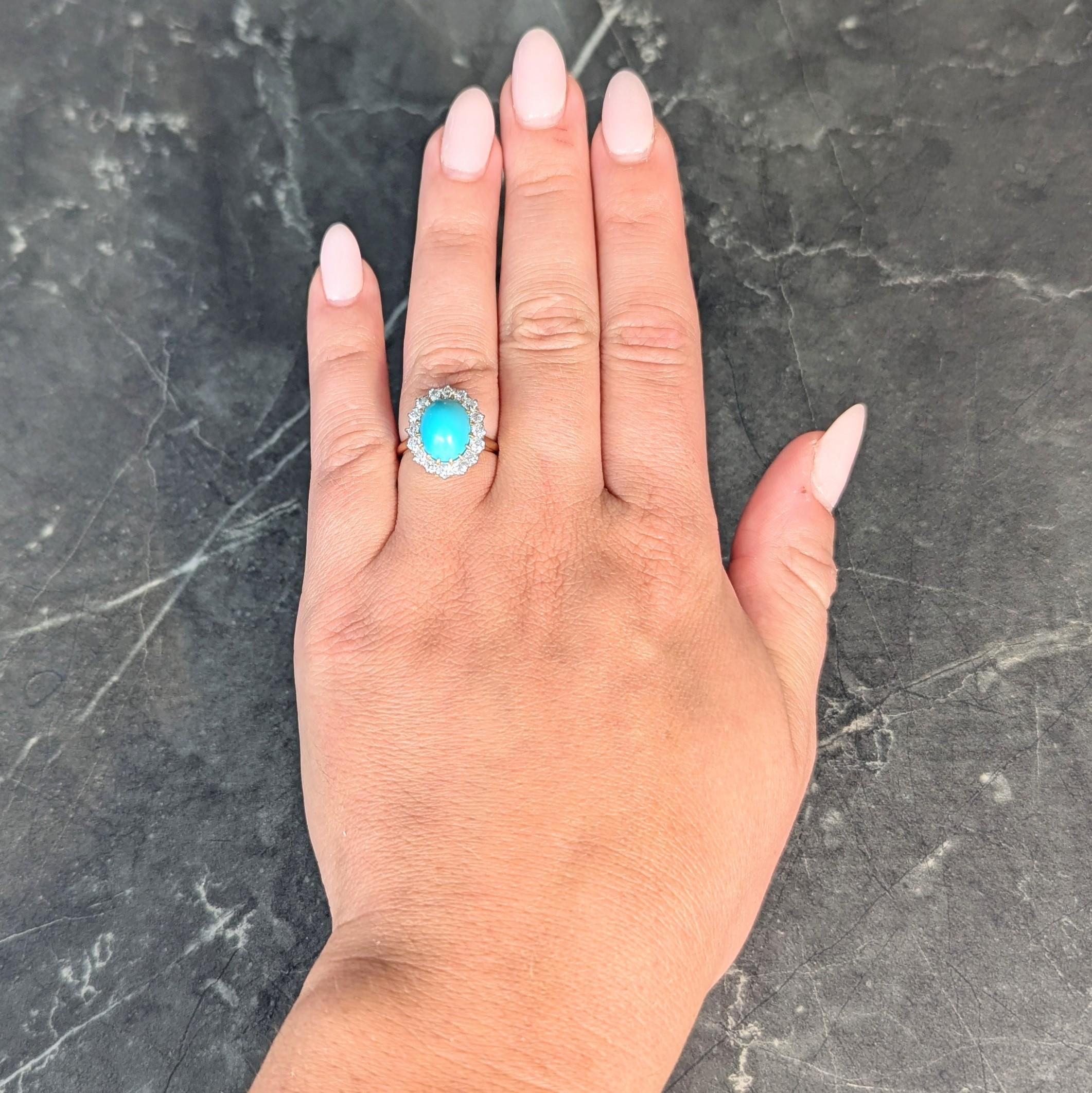 Centering an oval-shaped turquoise cabochon measuring 8.25 x 11.0 mm 
Opaque medium robin's egg blue and set with gold talon prongs
Accented by a halo surround of old European cut diamonds
Weighing approximately 0.96 carat total 
G/H color with VS2