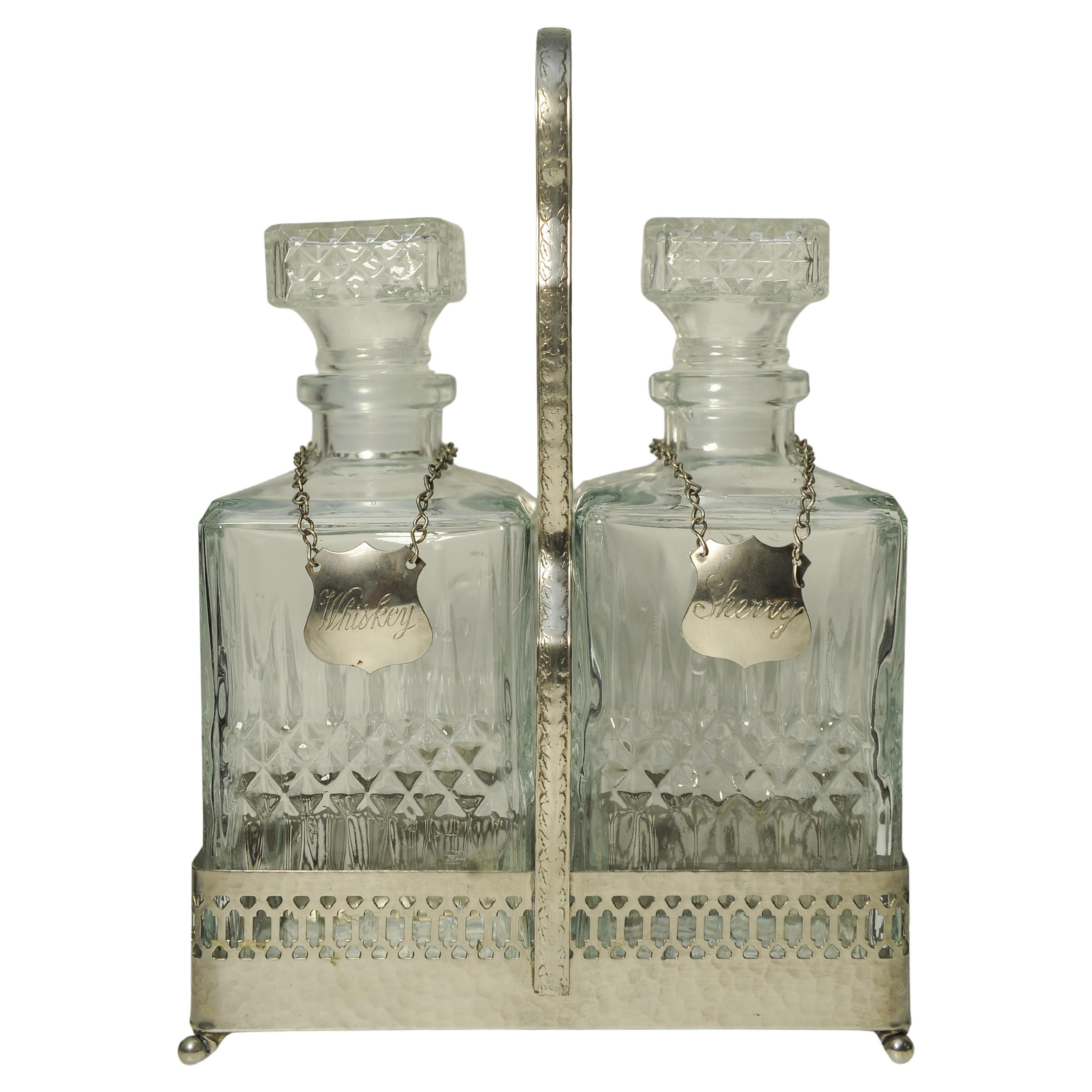 Tantalus edoardiano a due bottiglie con tappi in vetro tagliato Sherry e Whisky con collari a catena 

Ogni decanter ha un'etichetta di metallo, una con la scritta 