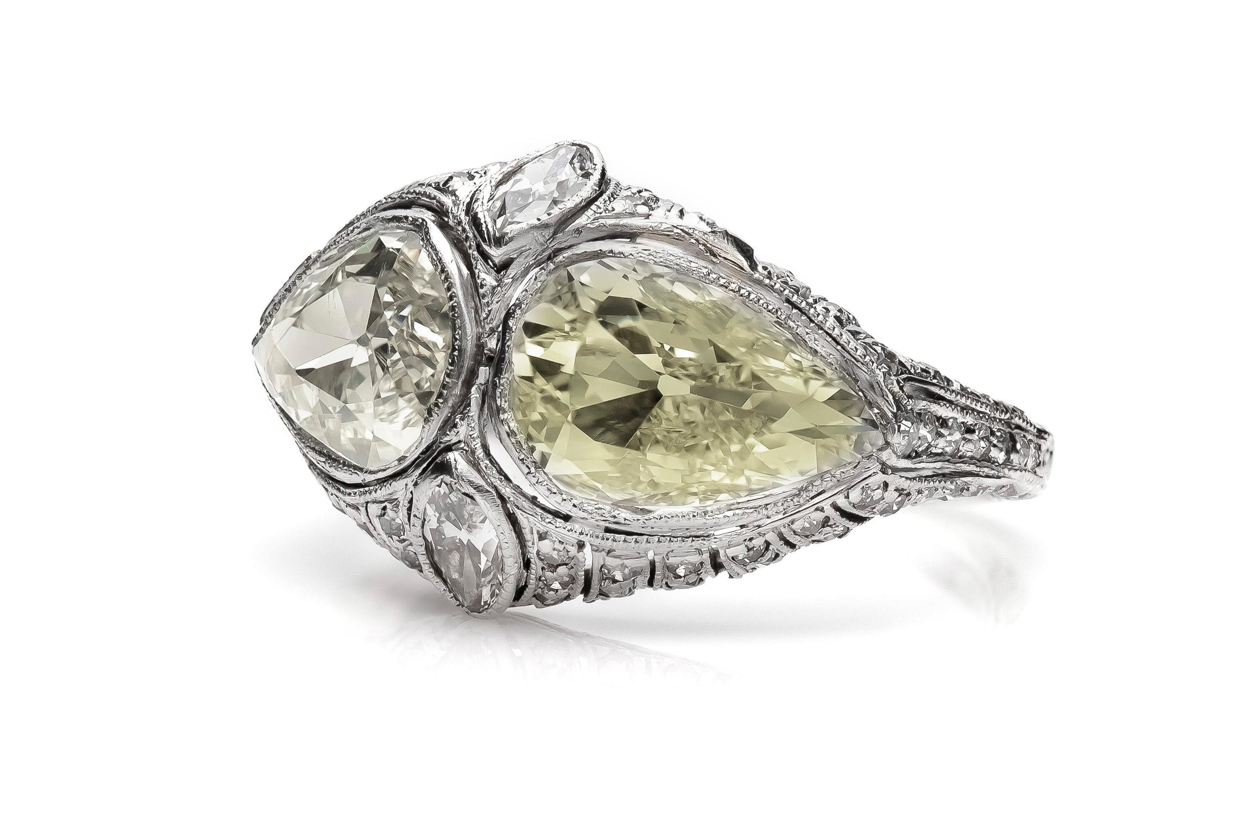 Finely crafted in platinum with two Pear Shaped center diamonds weighing approximately a total of 2.65 carats.
One diamond is Fancy Yellow color, VS2 clatiy, and the other is Light Fancy Yellow color, SI2 clarity.
The setting features two Marquise
