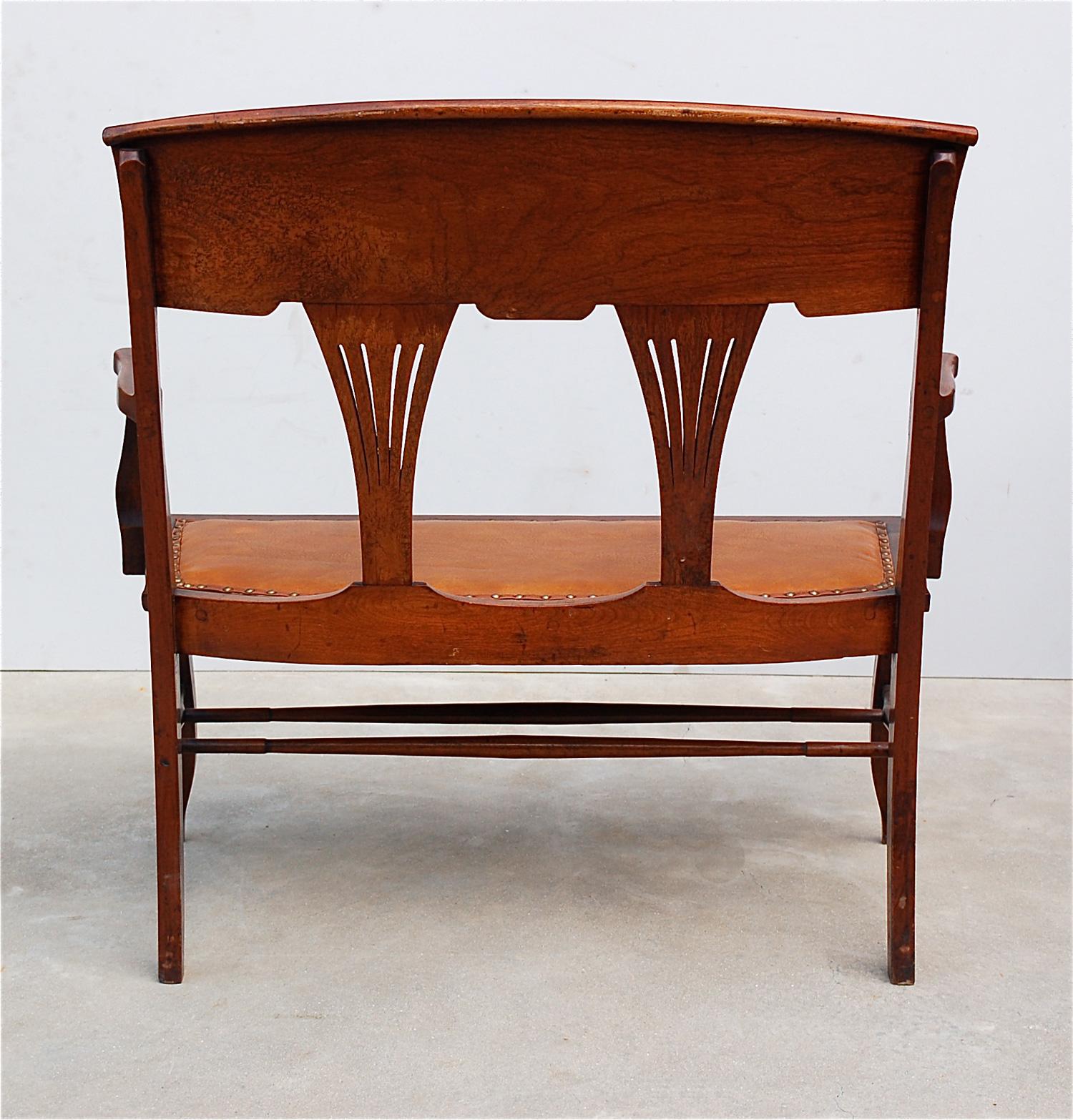 Charming occasional two-seat bench, settee, love seat, salon sofa or parlor settee in the Art Nouveau, Edwardian style. Lightly curved backrest with pierced fan shaped back splats. On cabriole legs with pegged joints, a scalloped apron and double