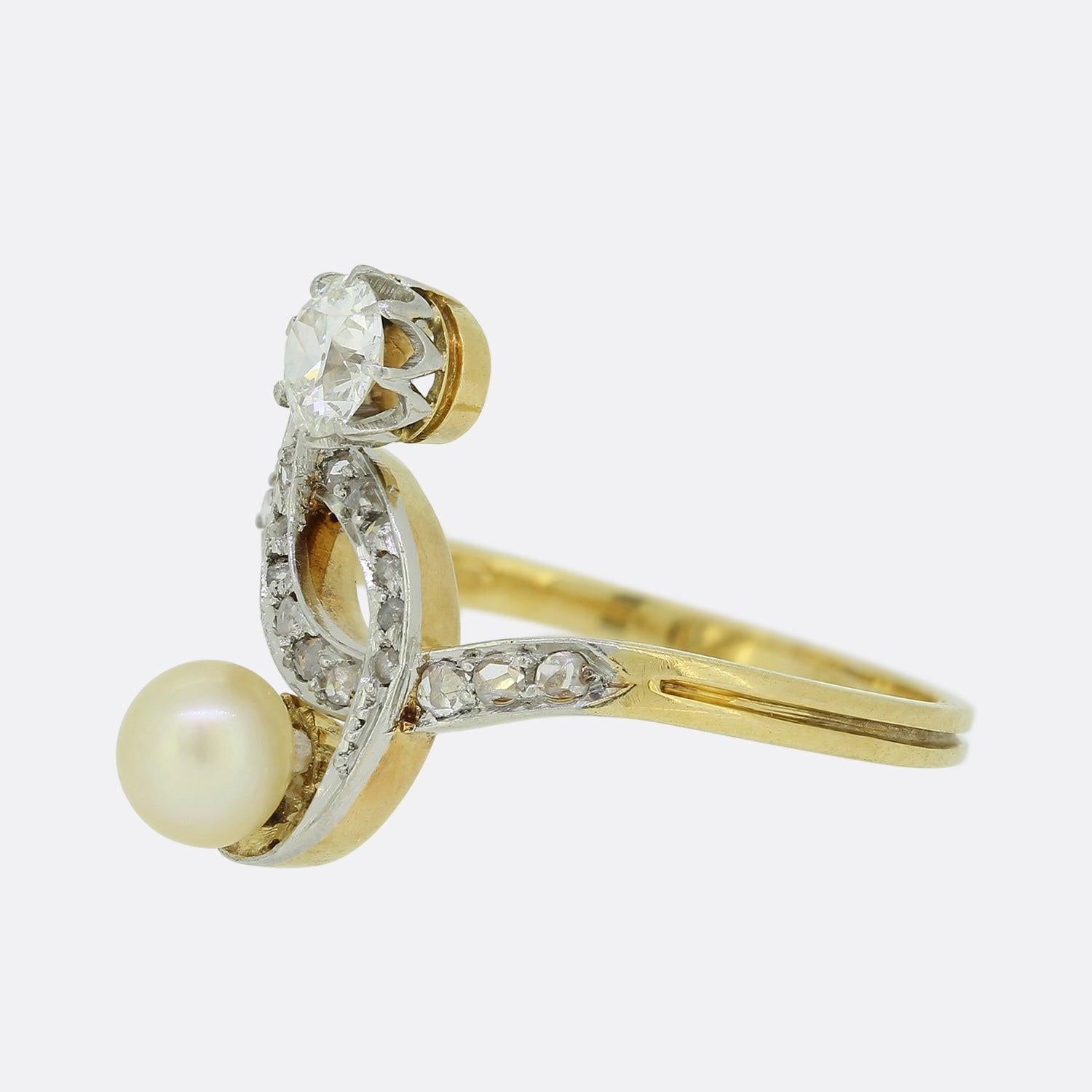 Here we have a charming pearl and diamond crossover ring from the Edwardian era. The swirling face of the piece showcases a round old cut diamond and a round natural pearl, with an interlocking backdrop of rose cut diamonds claw set in white gold