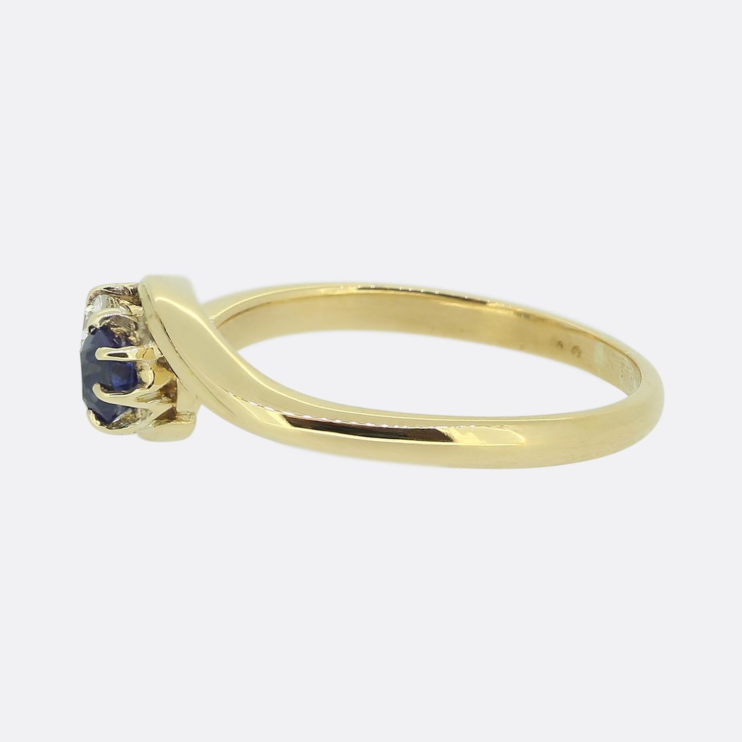 Here we have a charming two-stone twist ring dating back to the Edwardian era. This antique piece has been crafted from 18ct yellow gold and features a single round shaped sapphire with a rich navy colour tone alongside a chunky round faceted old