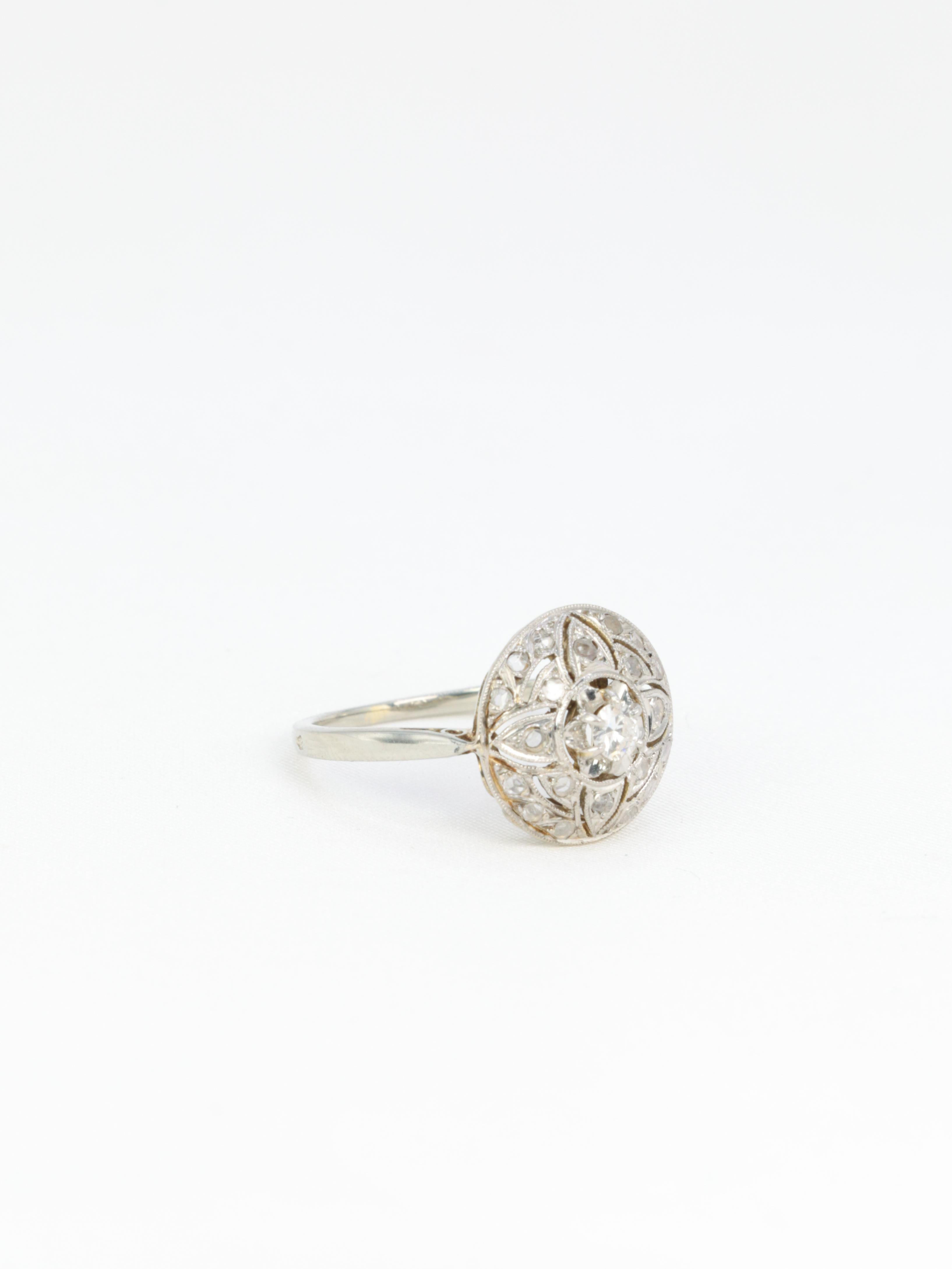 Ring aus 18 Kt (750°/°°) Weißgold mit einer Kuppel mit floralen Mustern, besetzt mit Diamanten im Rosenschliff von ca. 0,3 Karat. In der Mitte ein größerer Diamant im Brillantschliff mit einem Gewicht von ca. 0,15 Karat, Qualität G SI2 (mit bloßem