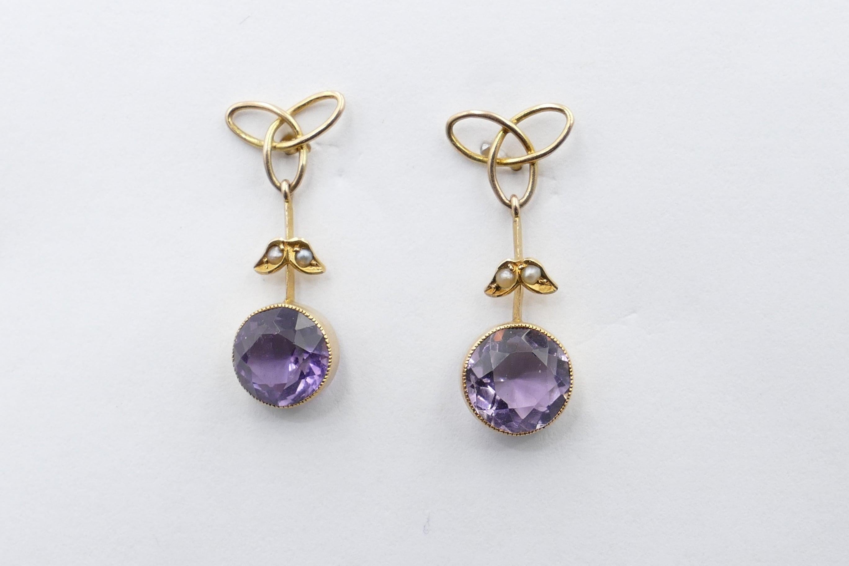Retailed by well known Melbourne High Class Jewellers Catanachs, this pair of Antique Earrings features 2 strong, medium purple in Colour, Amethysts, Clarity eye-clean, Round Cut, Bezel Set, with 4 Seed Pearls, white in colour with silver overtones.