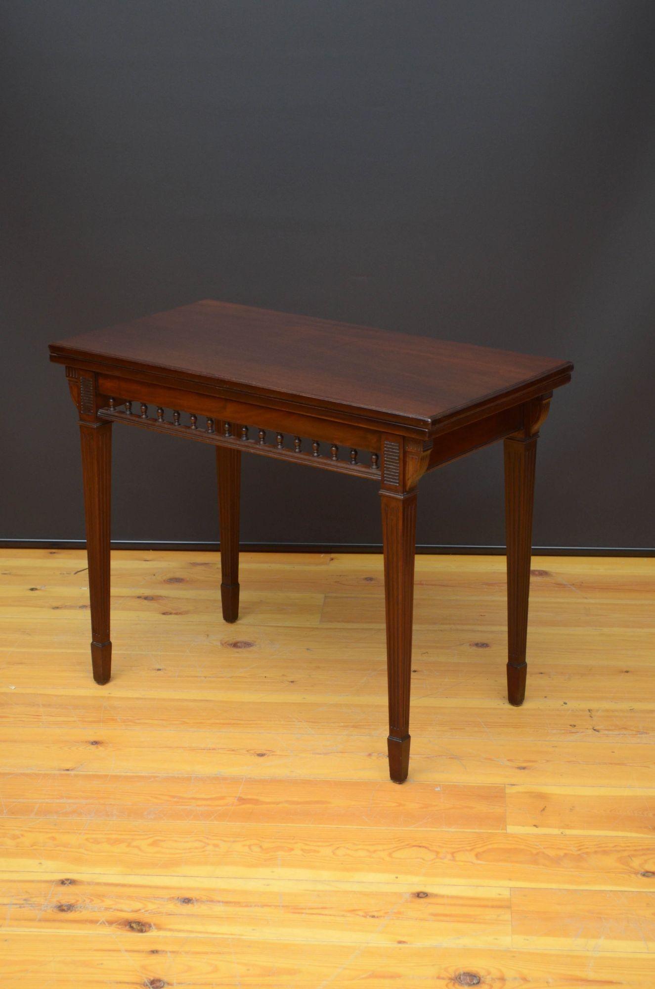 J023 A superb quality Edwardian Edwards and Roberts card table in mahogany, having figured fold over to enclosing new baize above figured mahogany frieze with decorative spindles, standing on tapered reeded legs terminating in spade feet. This