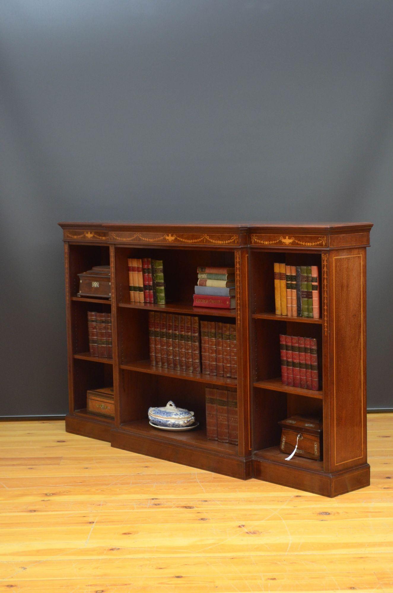 Sn5417 Libreria a giorno tardo-vittoriana di pregio, con piano in mogano figurato con fascia trasversale in raso e intarsio di vasi al centro, fregio intarsiato in raso raffigurante vasi, campane di lepre e festoni e fiocchi, il tutto sopra tre