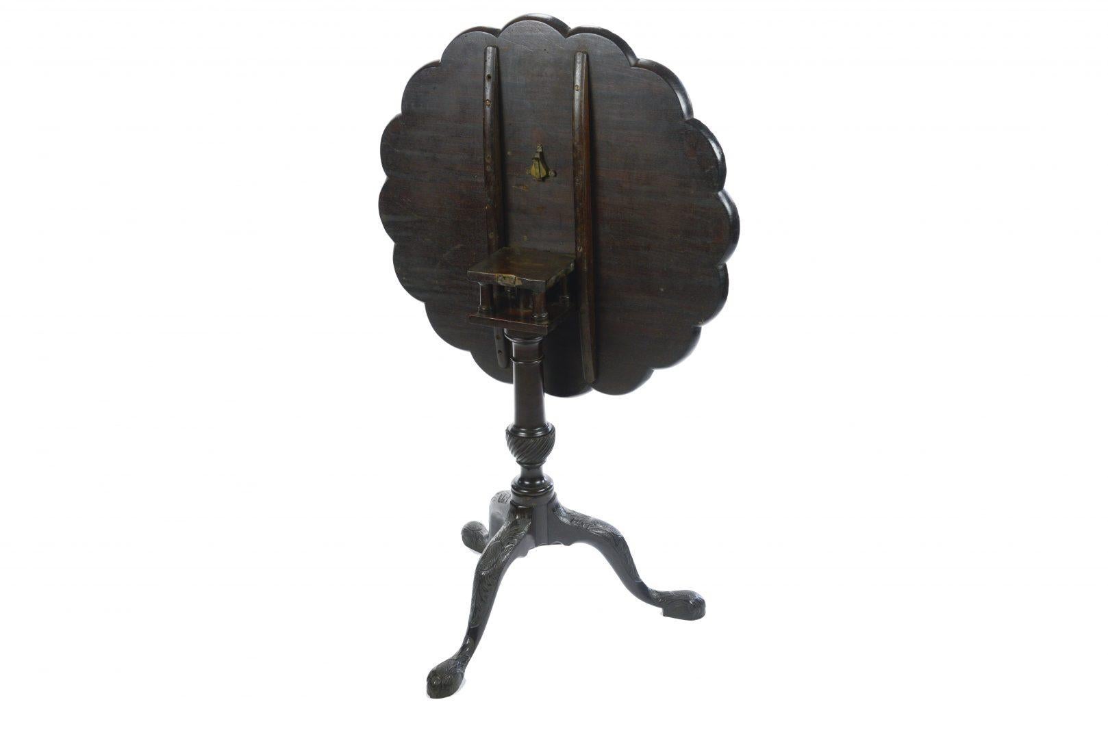 Chippendale style, early 19 century, Edwards & Roberts: a mahogany supper table, the shaped top with eight roundels with a central foliate motif against a matted ground, on a birdcage base and vase-shaped turned upright and three cabriole legs with
