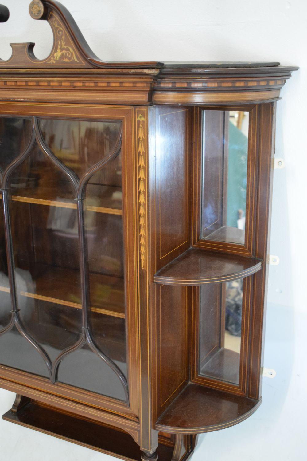 Edwards & Roberts.
An Edwardian Aesthetic Movement Queen Anne Revival mahogany wall cabinet with floral inlaid swan neck pediment and chequer and line inlays throughout. A central astragal glazed door opening to reveal a pair of adjustable shelves