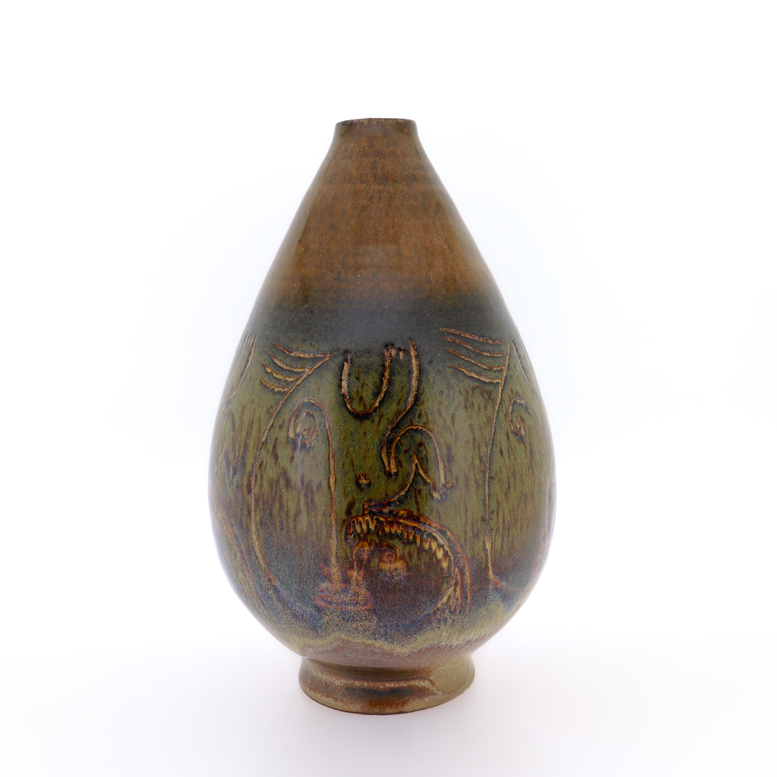 Un bel vaso in ceramica d'arte modernista.

Di Edwin e Mary Scheier.

A forma di goccia con un piccolo piede. Con smalto marrone su tutta la superficie e smalto multicolore al centro che passa dal nero al verde, dal blu al marrone. Con disegni a