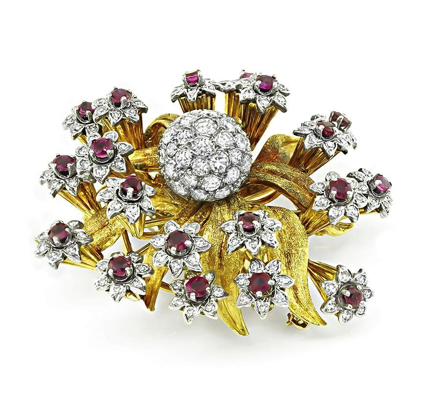 Este es un elegante alfiler de flor de oro amarillo y blanco de 18 quilates de Edwin Pearl. El alfiler está engastado con brillantes diamantes de talla redonda y rubíes que pesan aproximadamente 4,00 ct y 2,00 ct respectivamente. El color de los