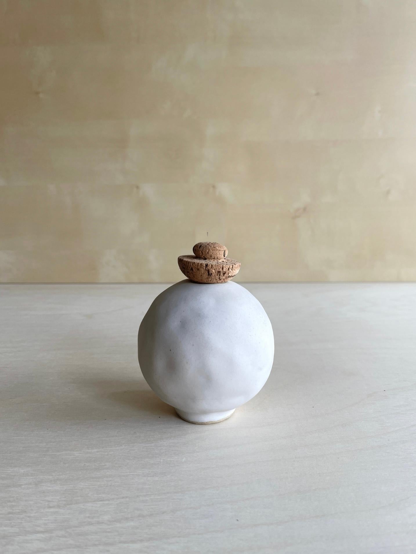 Weiße Edwina-Vase von Meg Morrison
Ein Unikat.
MATERIALIEN: Keramik, Kork.
Abmessungen: Ø 10 x H 13 cm.

Alle Größenangaben sind Richtwerte. Obwohl Vasen wasserdicht sind, kann sich am Boden Kondenswasser bilden. Bitte schützen Sie empfindliche