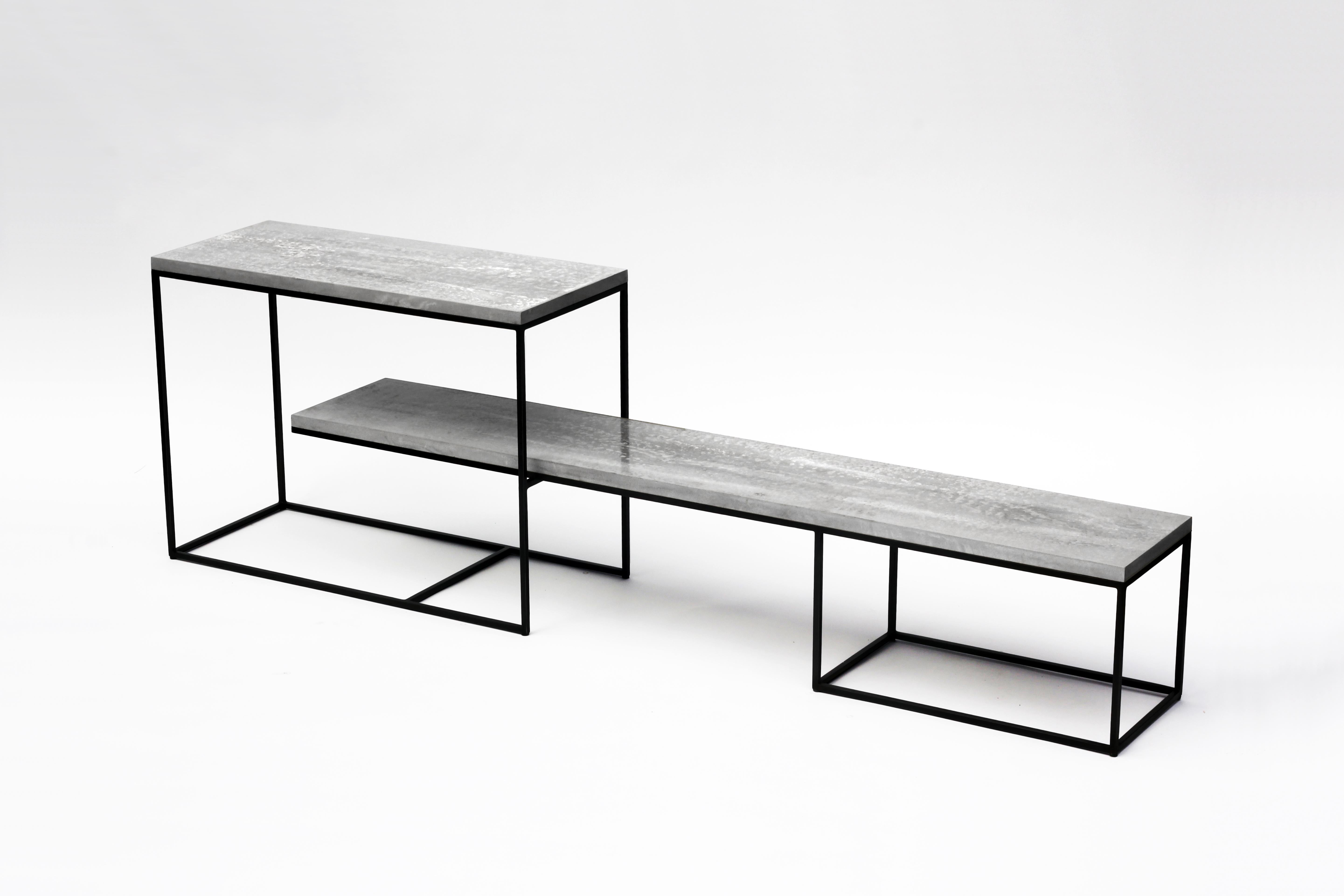 The EE bench-console with exposed concrete edges from Joshua Howe Design is a study in grace and geometry. Sliding together seamlessly, the two blackened steel bases form an adjustable length multi-tier support structure for each of two hand poured