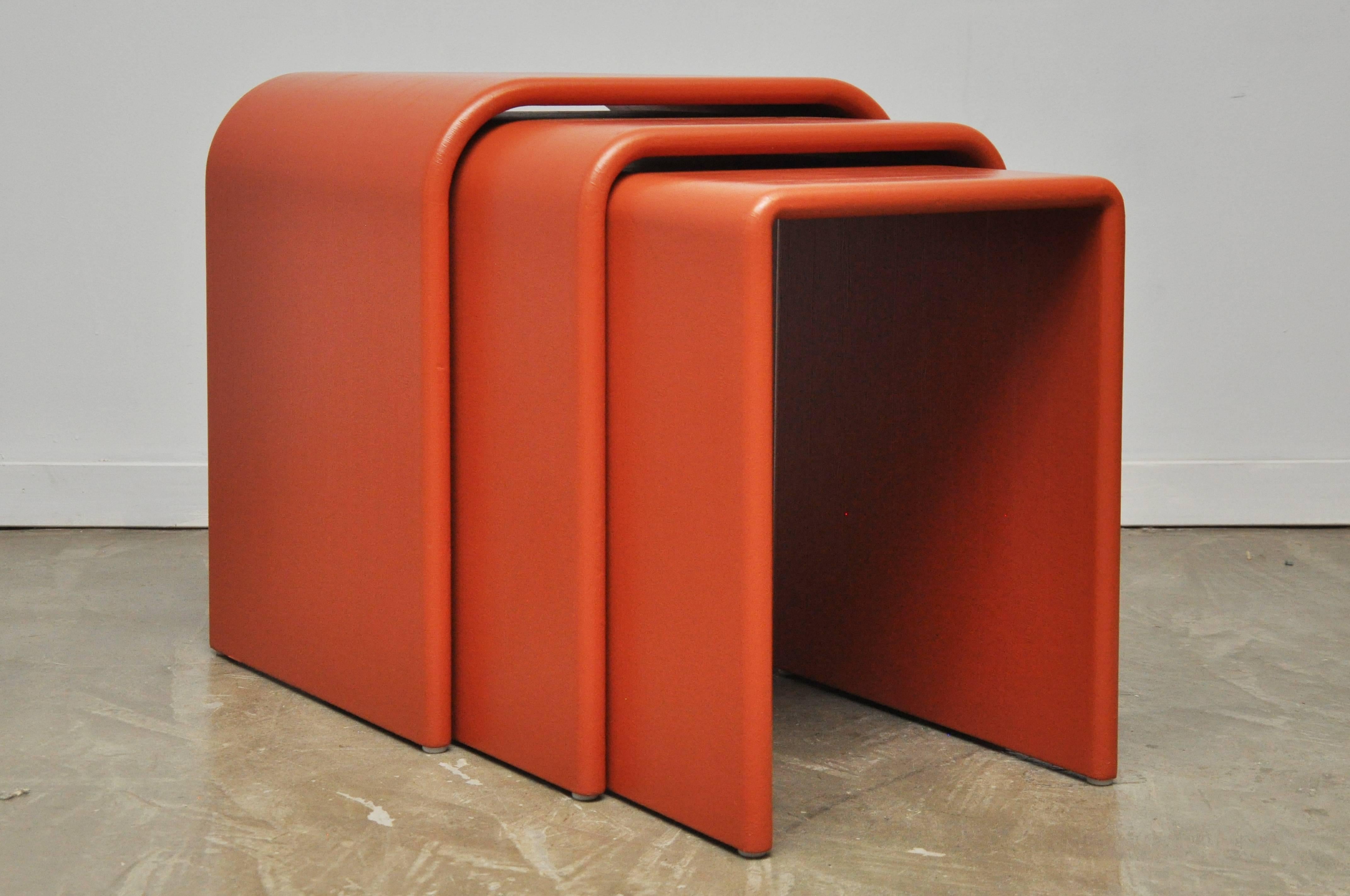 Set of three Eel Skin nesting tables. Waterfall form tables wrapped in coral dyed eel skin, circa 1970s.