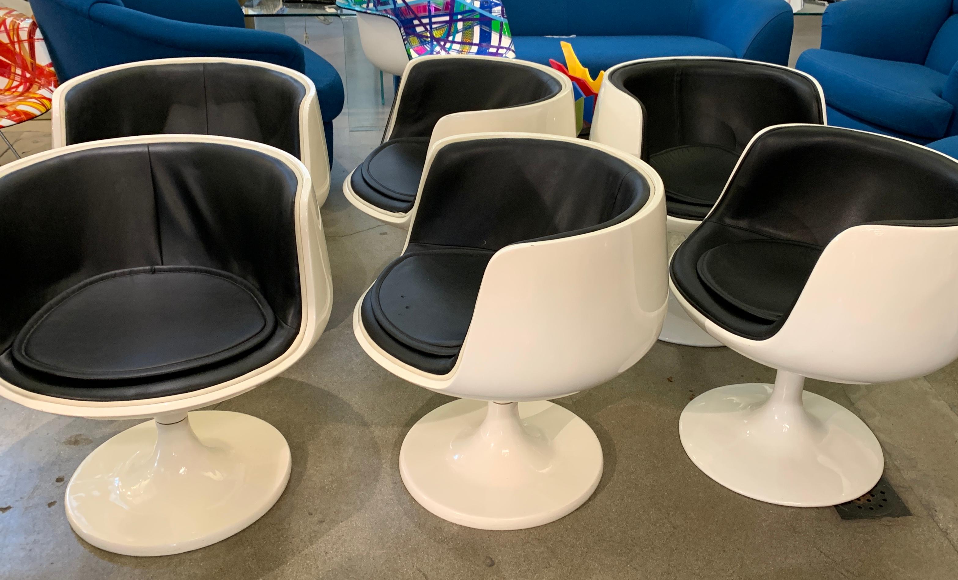 A set of six Eero Aarnio chairs. 4 are older and quite heavier with two part base construction. These are his Cognac chairs. The lighter weight two are single piece bases and are his later VSOP chairs. The older ones are slightly more ivory and