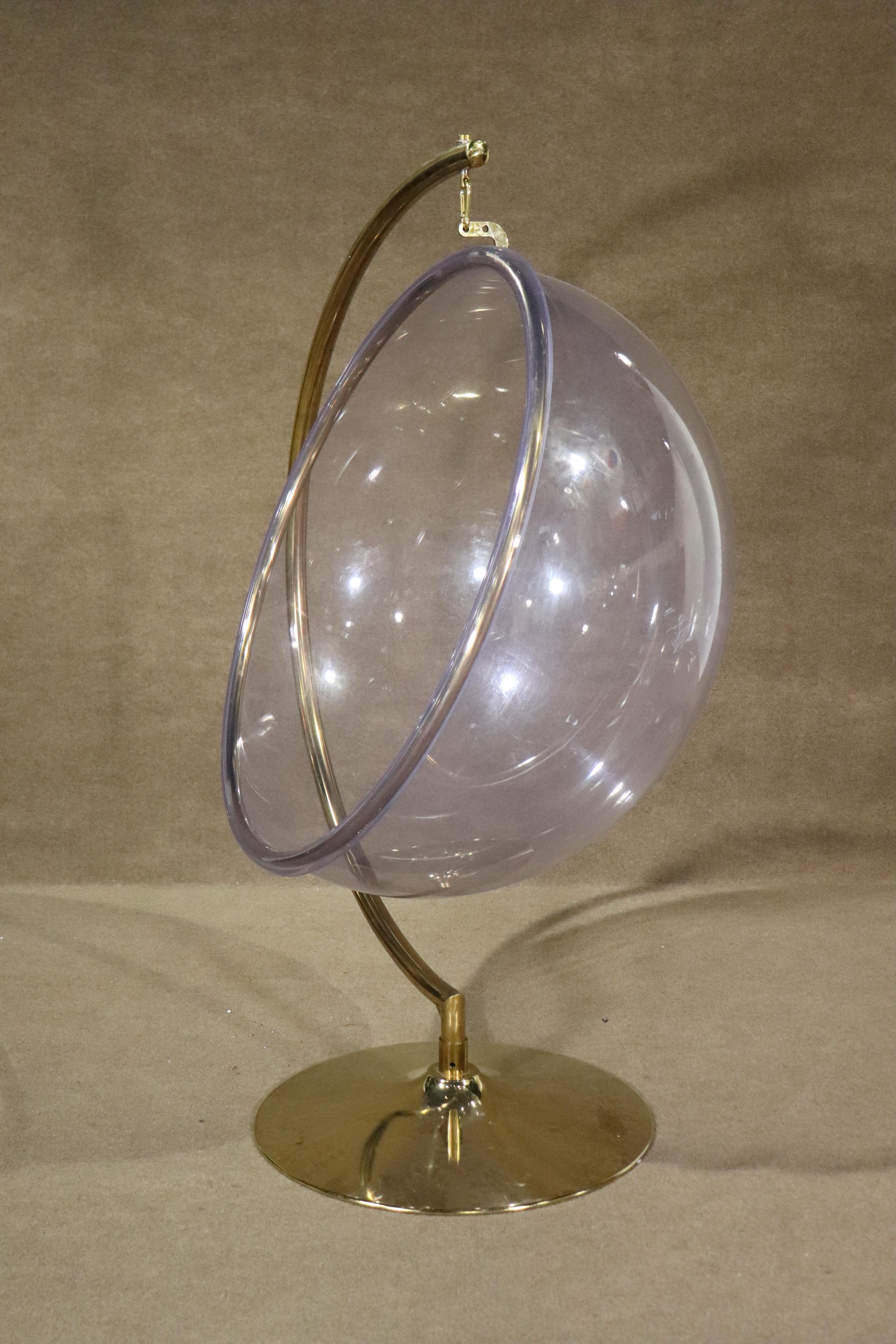 This suspended bubble chair was originally designed by Eero Aarnio, made in Finland. Clear acrylic bubble hanging from a polished brass arch frame.
Please confirm location NY or NJ