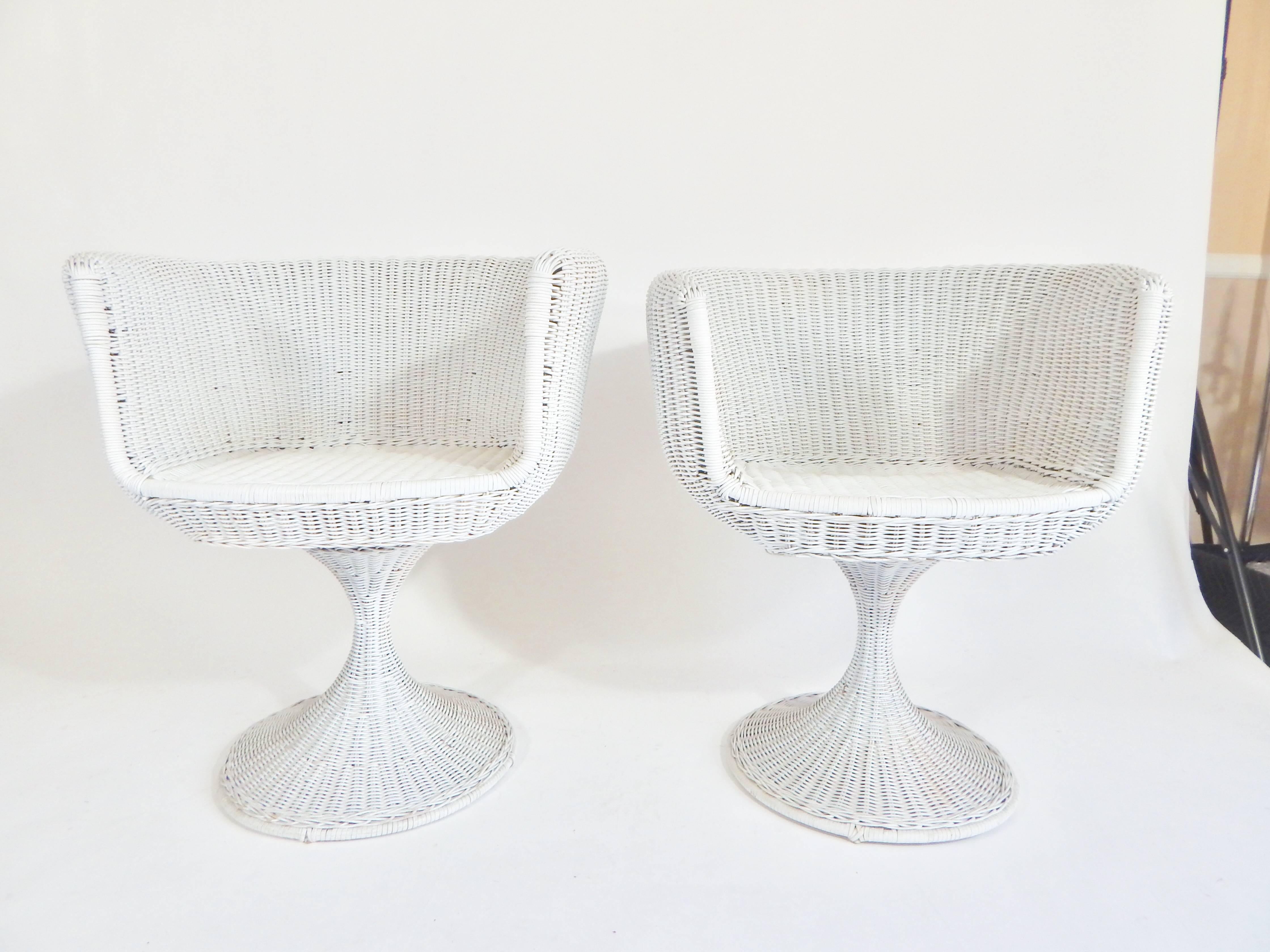 Midcentury, 1960s pair of Eero Arnio designed wicker rattan chairs and glass top table set. Tulip base swivel chairs. Very good original found condition in white.  Glass top is in excellent condition. Cushions appear to have been made for the chairs