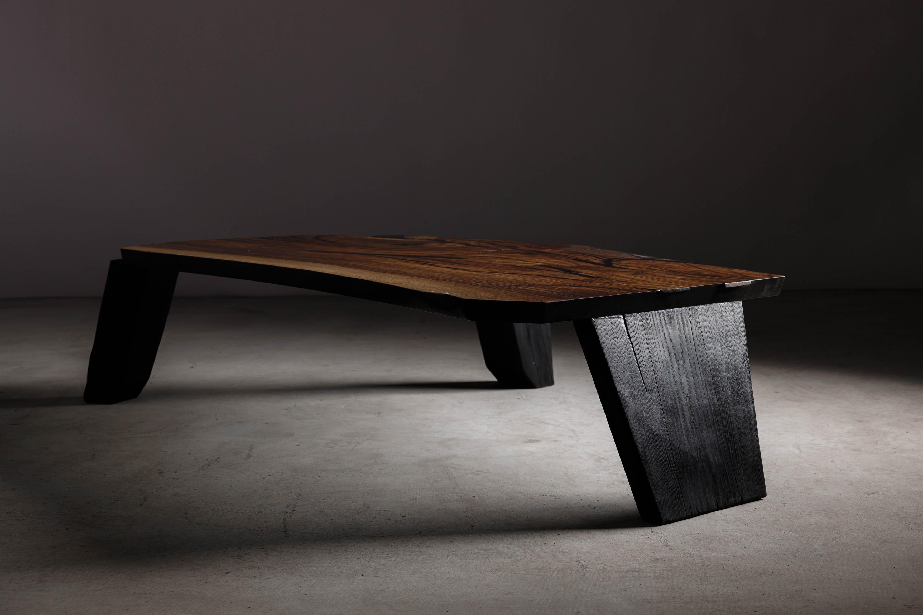 Indulge in the luxurious texture and warmth of this hand-made brutalist walnut coffee table from Eero Moss Studio. Meticulously crafted with the finest materials and fire, this coffee table is a stunning example of craftsmanship.

The natural