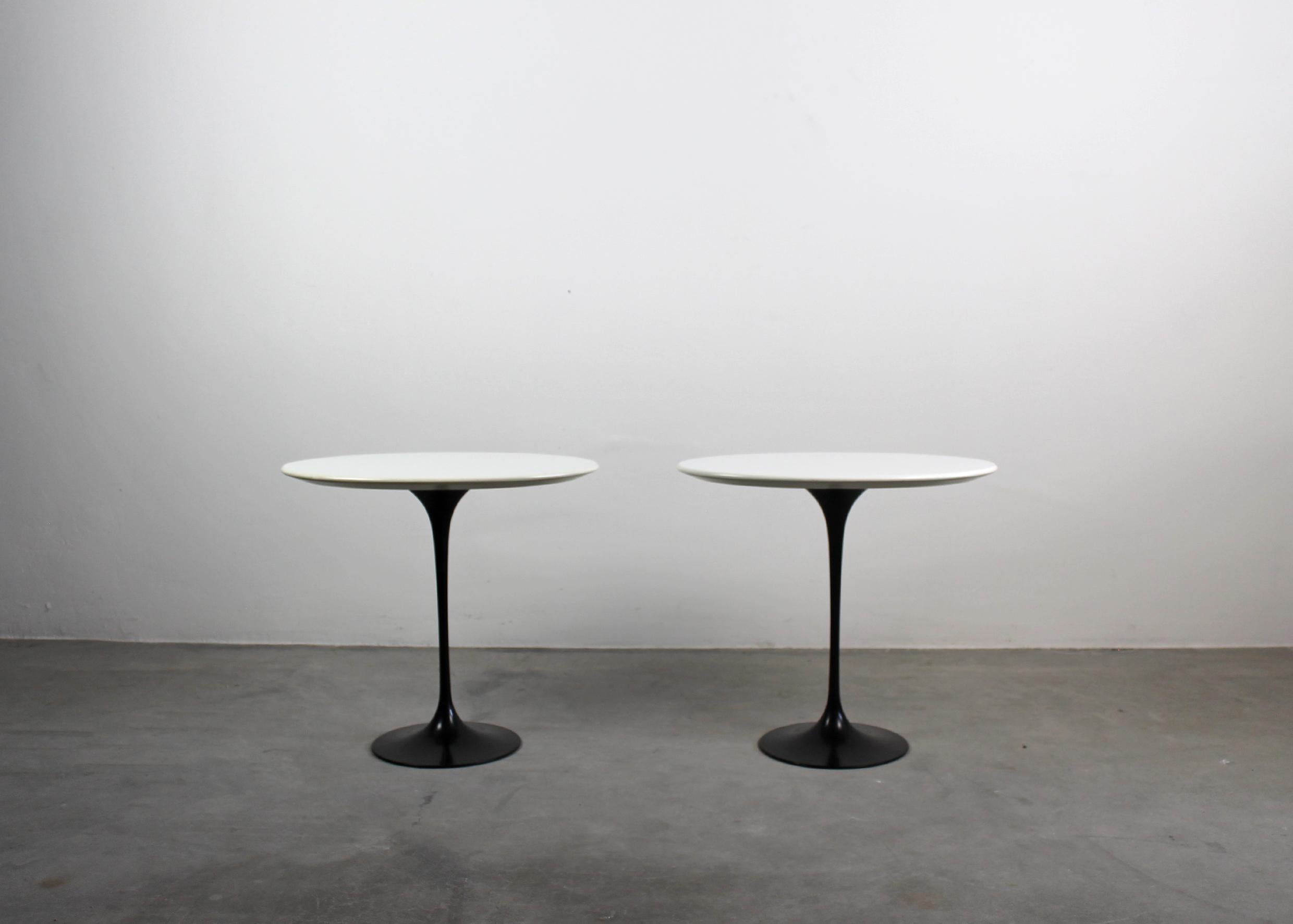 Set of two coffee tables with a black pedestal base in painted die-cast aluminum and an oval-shaped top in white lacquered wood.

These two tables were manufactured in the 1990s in the style of the designer Eero Saarinen

Eero Saarinen was a
