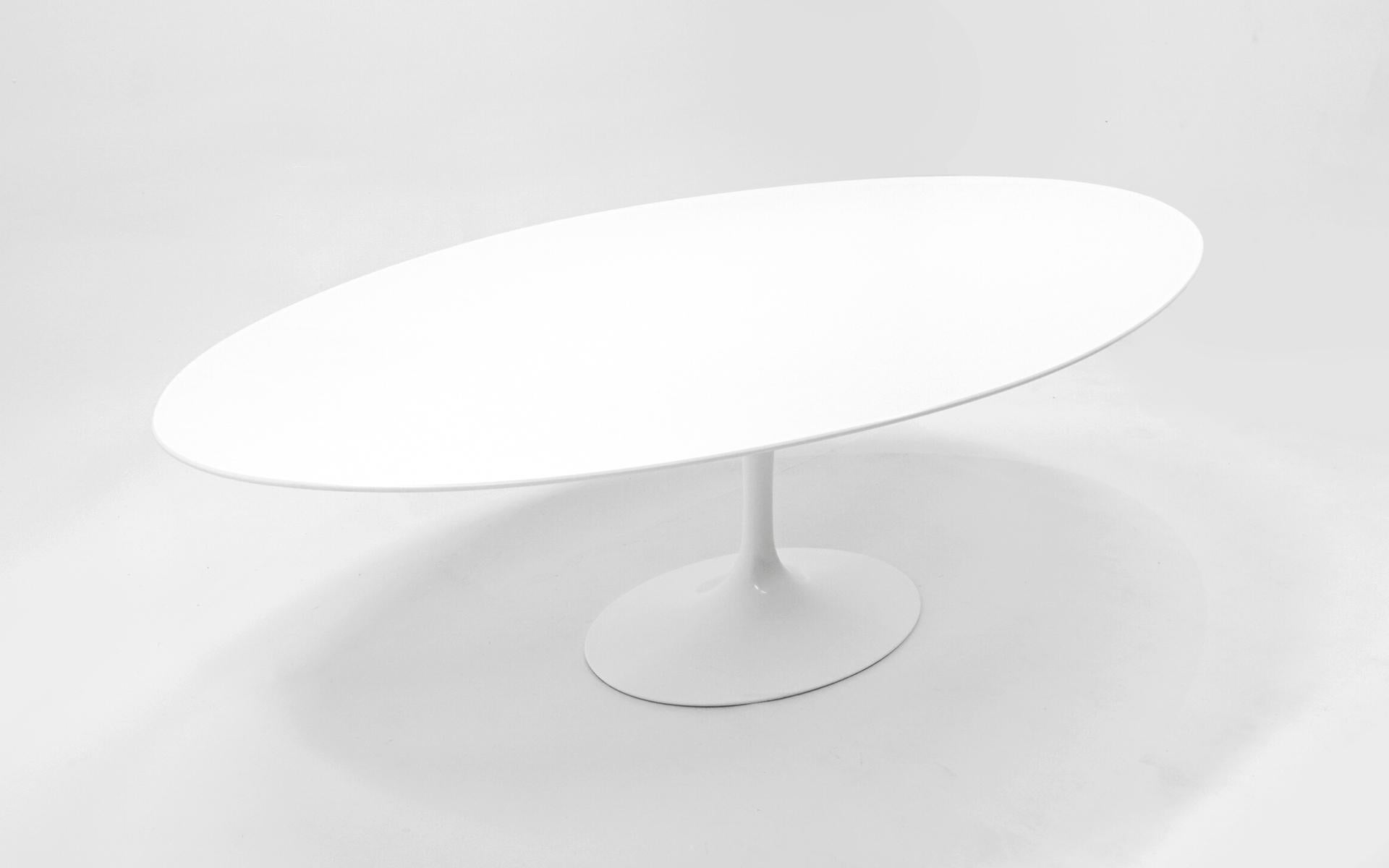 Oval dining / conference table with white laminate top and white lacquered aluminum tulip base designed by Eero Saarinen for Knoll.  This is the largest table from this line. This table was produced in the 2000s by Knoll and is in virtually like new