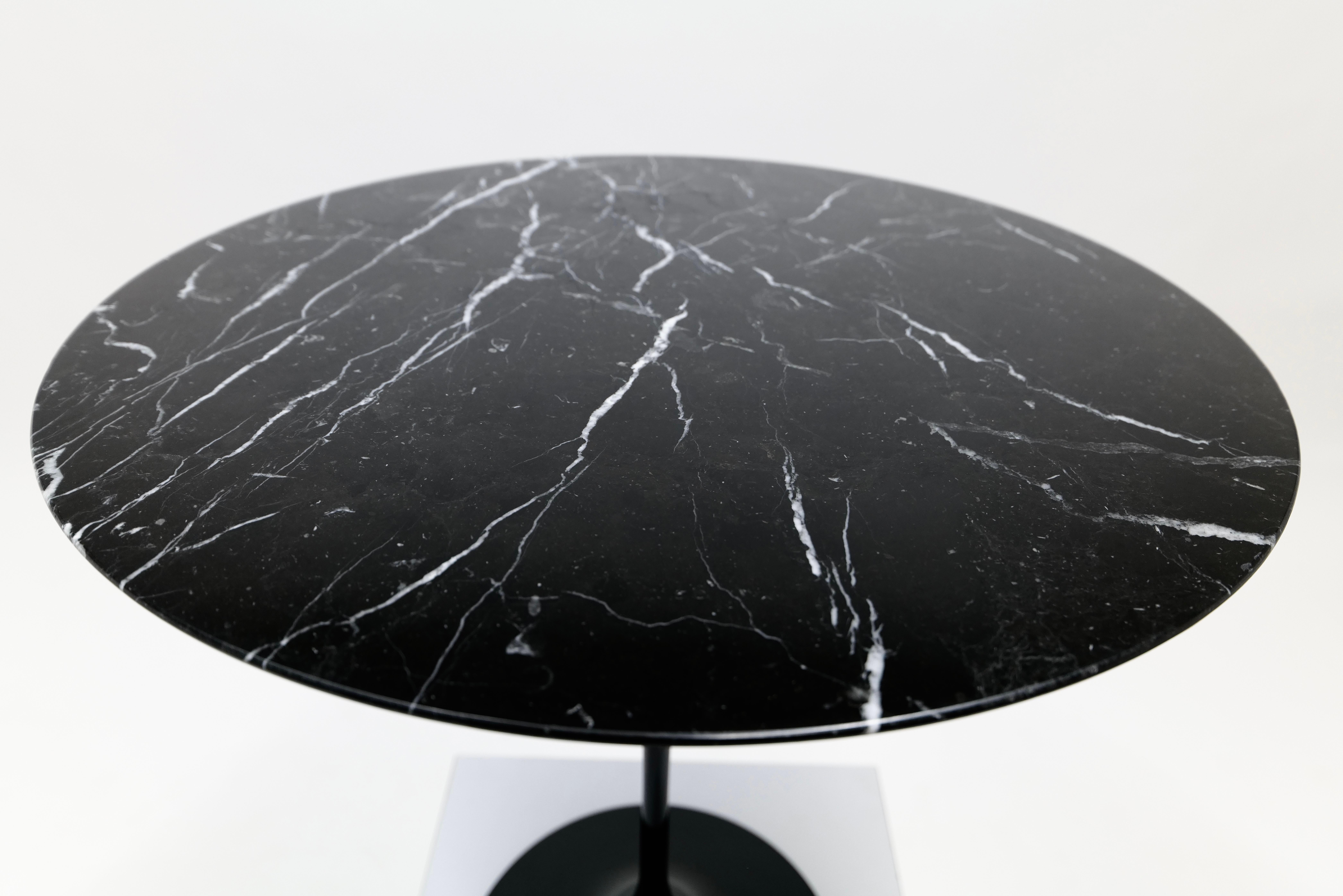The black marble pedestal side table by Eero Saarinen for Knoll is a striking piece of mid-century modern design. The table features a round tabletop made from richly veined black marble, polished to a high gloss finish that enhances its luxurious