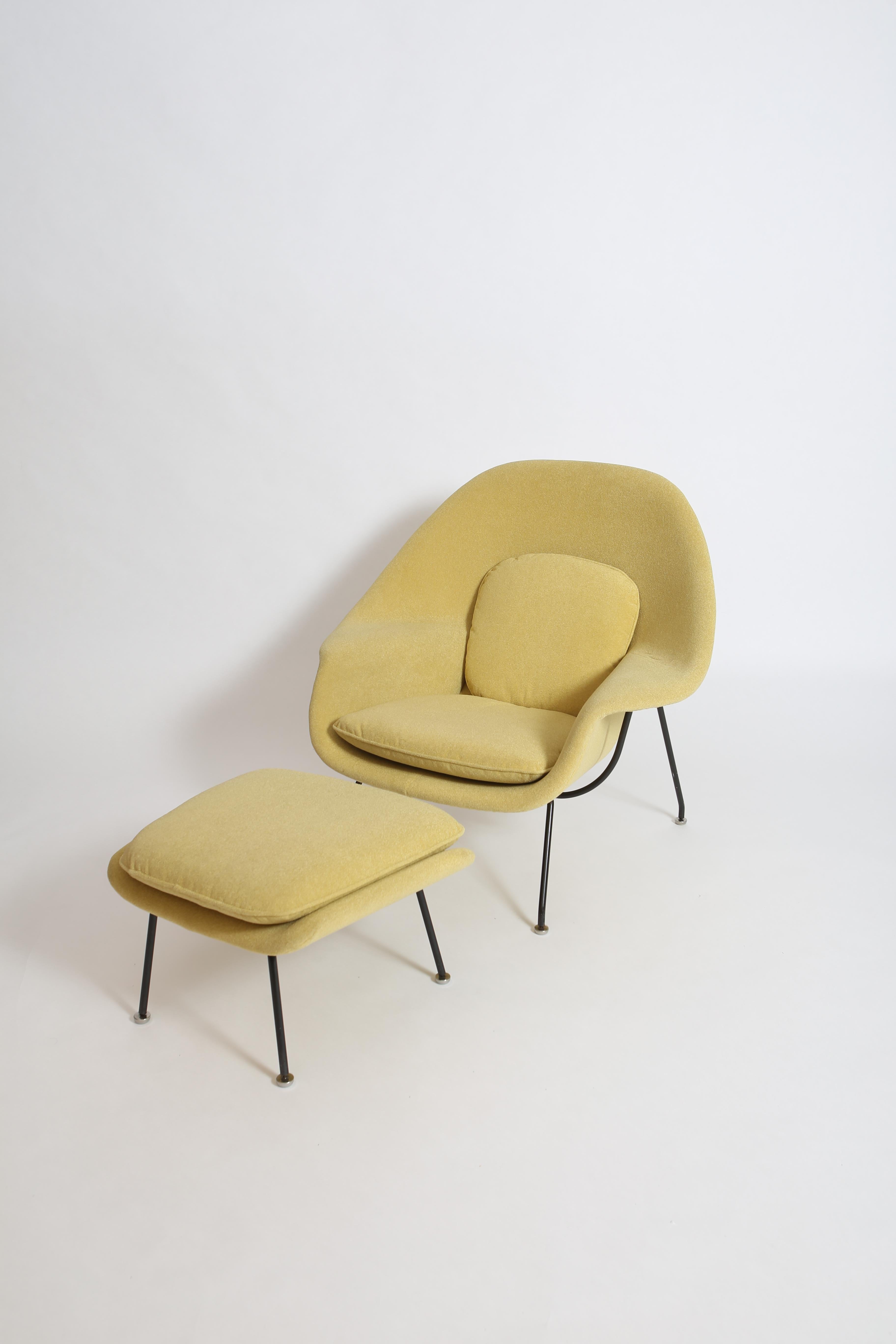 Classic “Womb Chair” and ottoman by Eero Saarinen for Knoll. This example dates to the early 1960s and has been recently reupholstered in a Knoll fabric. The color is a pale citron yellow. Early black steel frame shows age-appropriate wear, but