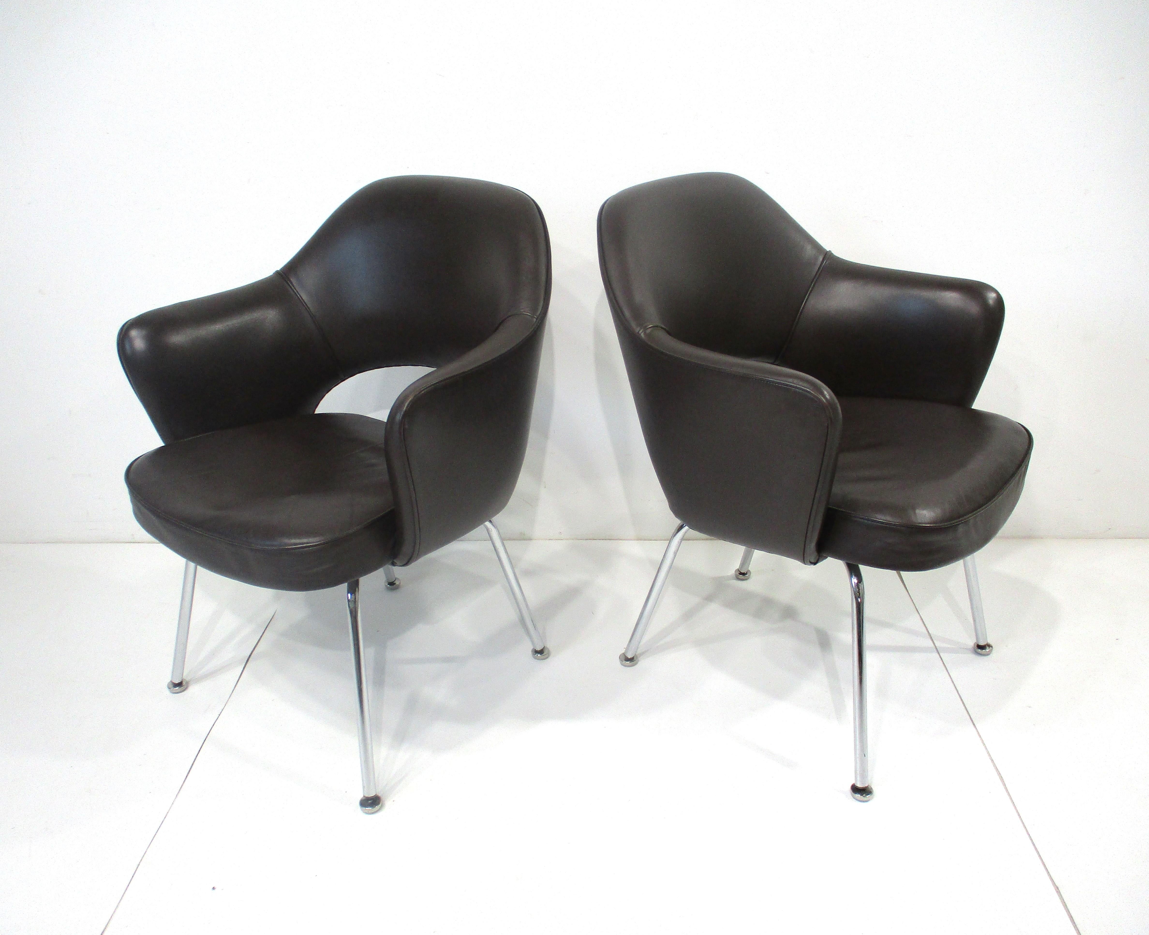 A matching pair of soft , rich spinney back dark brown leather upholstered Executive lounge arm chairs . Polish chromed legs with foot pads to protect your floors give the chairs a sharp tailored look and feel perfect for home or a high end office .