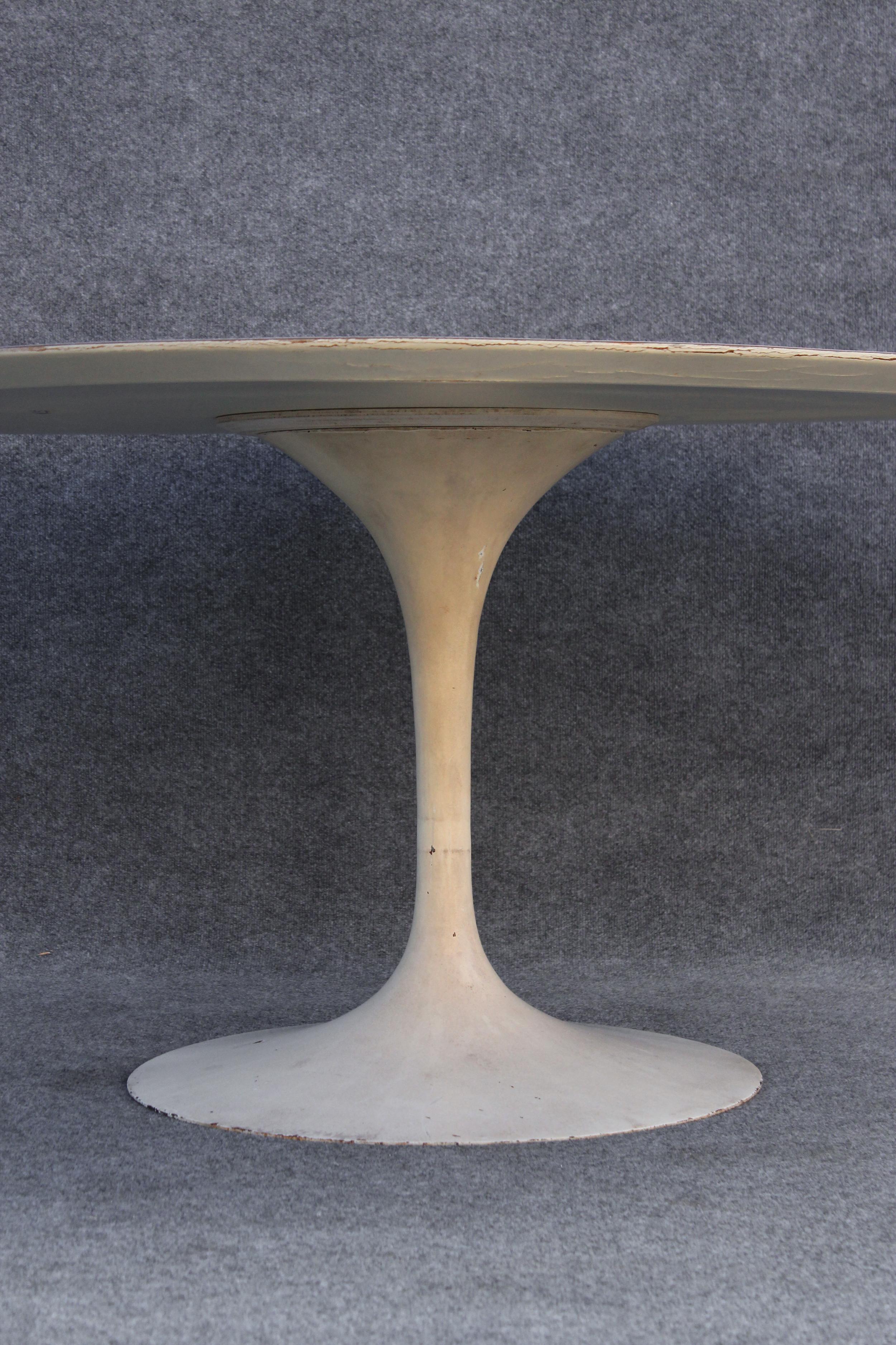 Conçue en 1957 par Eero Saarinen, cette table a été produite par Knoll peu de temps après. L'étiquette sur le dessous de la table indique qu'elle date d'environ 1961, ce qui en fait l'une des plus anciennes tables existantes. Le plateau est revêtu