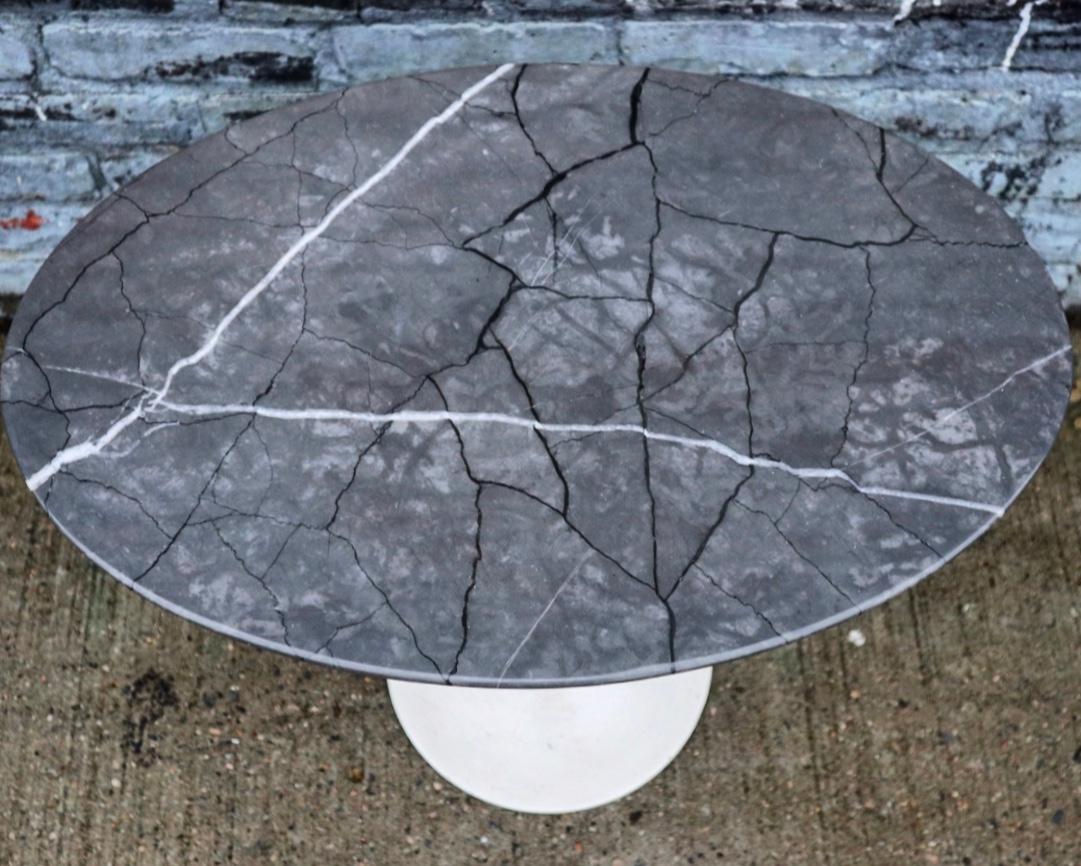 Gorgeous side tulip table by Eero Saarinen for Knoll. Elliptical marble top blast lovely colors and textured veins. A very handsome stone. White iron base in good condition with original paint.