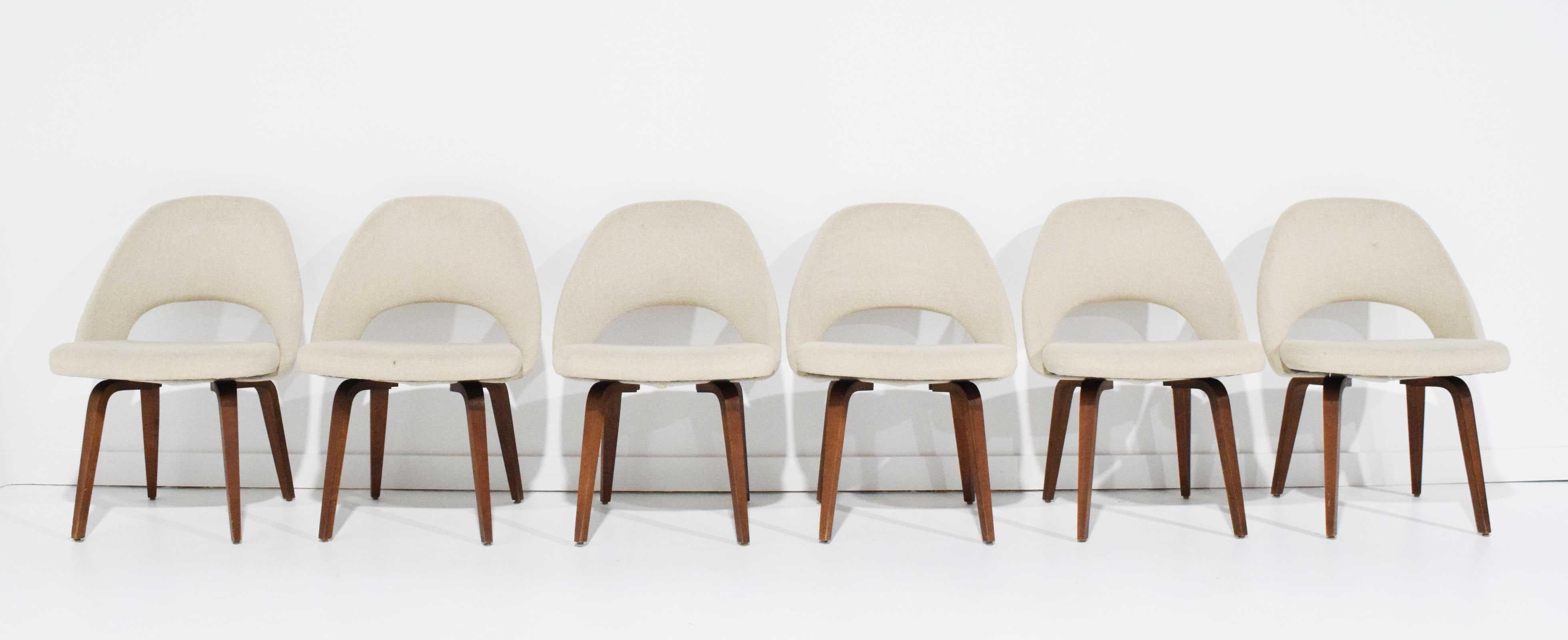 A very nice set of six dining chairs by Eero Saarinen for Knoll. Chairs feature walnut legs and an off-white Knoll fabric. Fabric in good condition but would benefit with a cleaning.