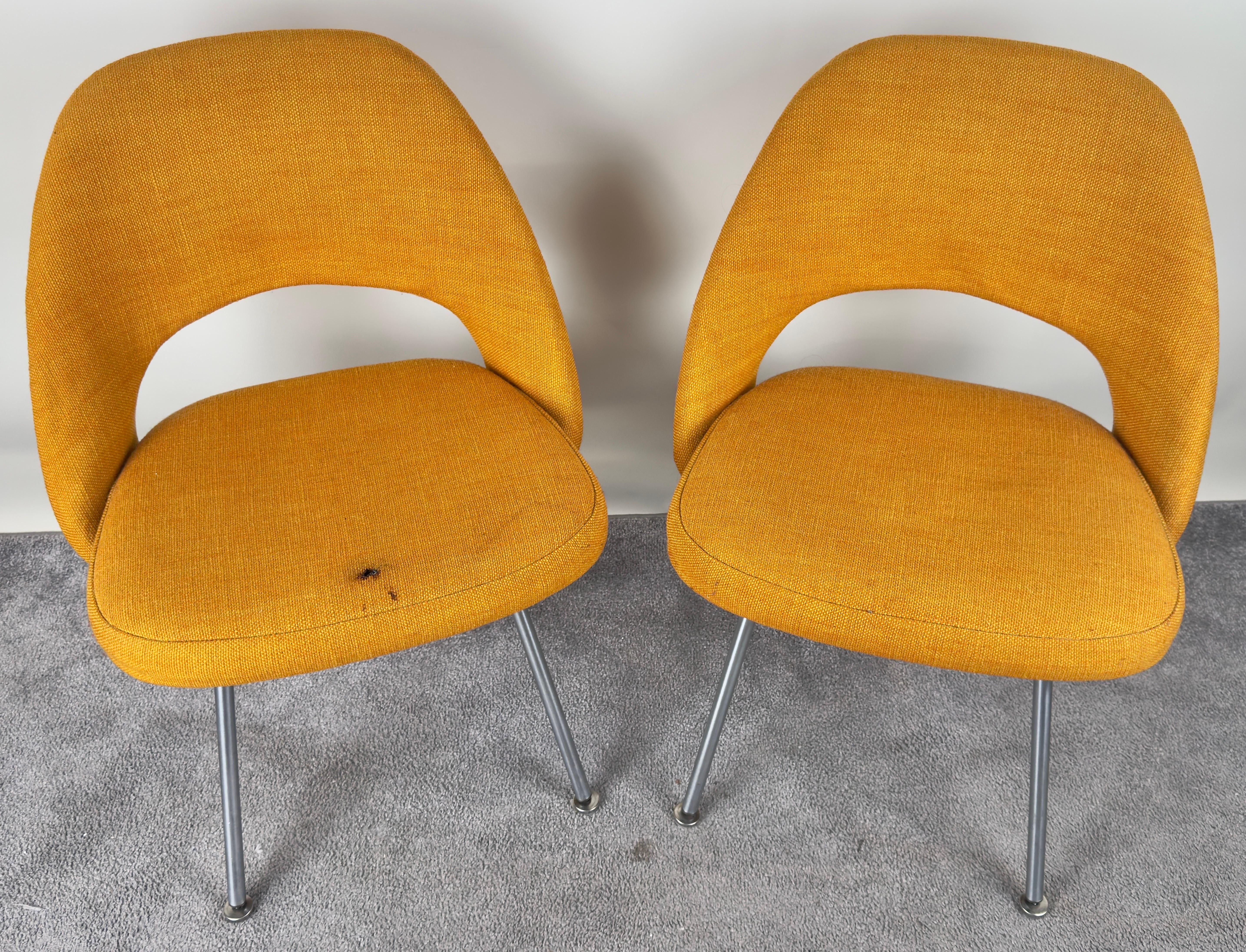 Cette paire de chaises d'appoint du milieu du siècle par Eleg Saarinen pour Knoll Associates incarne l'essence de l'élégance épurée et moderniste qui a défini l'époque. Revêtues d'un tissu orange curcuma vibrant, ces chaises apportent une touche de