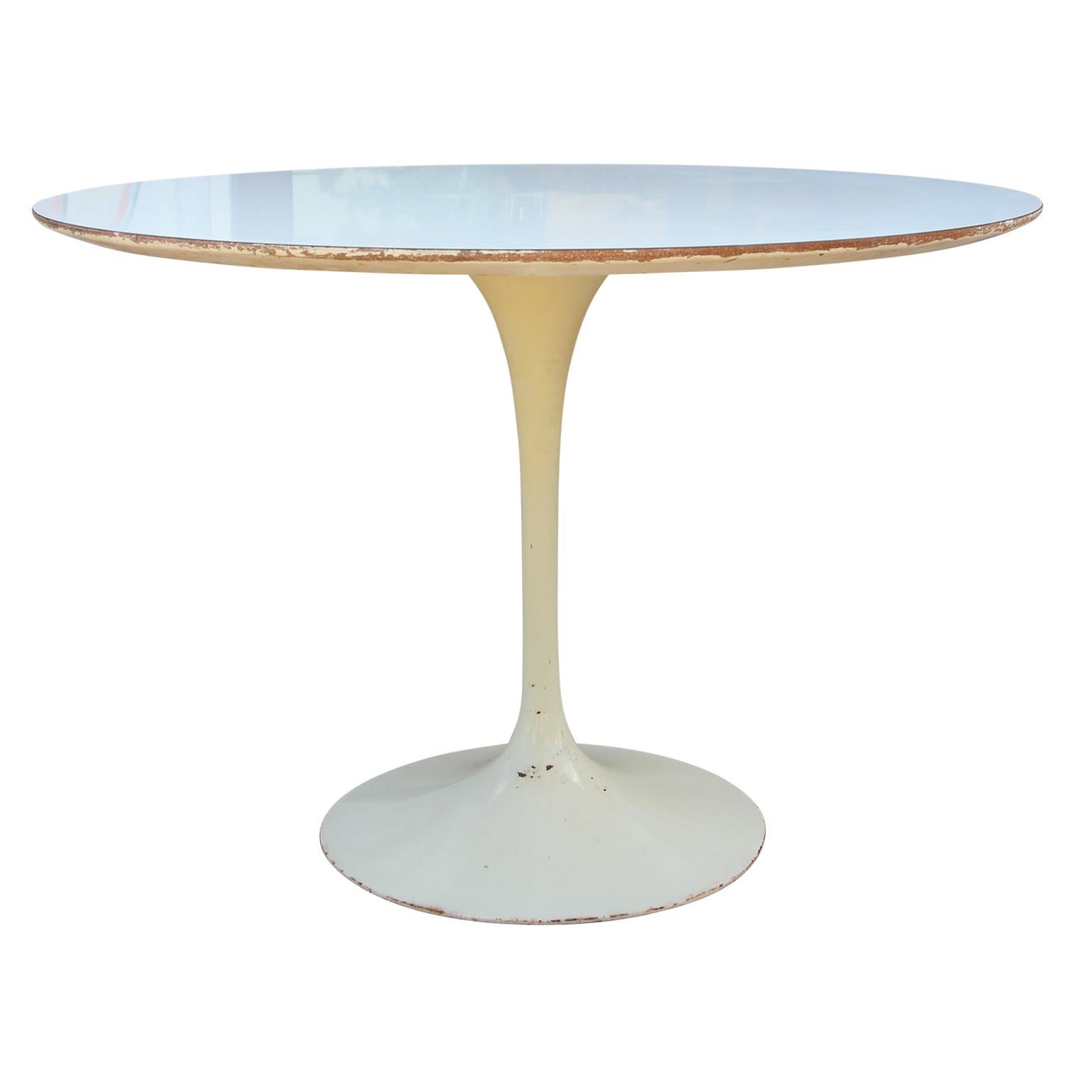 1950s-1960s Tulip dining table designed by Eero Saarinen and produced by Knoll. 42 inch diameter round white laminate top with beveled underside edge. Cast aluminum base is powder coated in gloss white. Original Knoll label on underside. Some paint