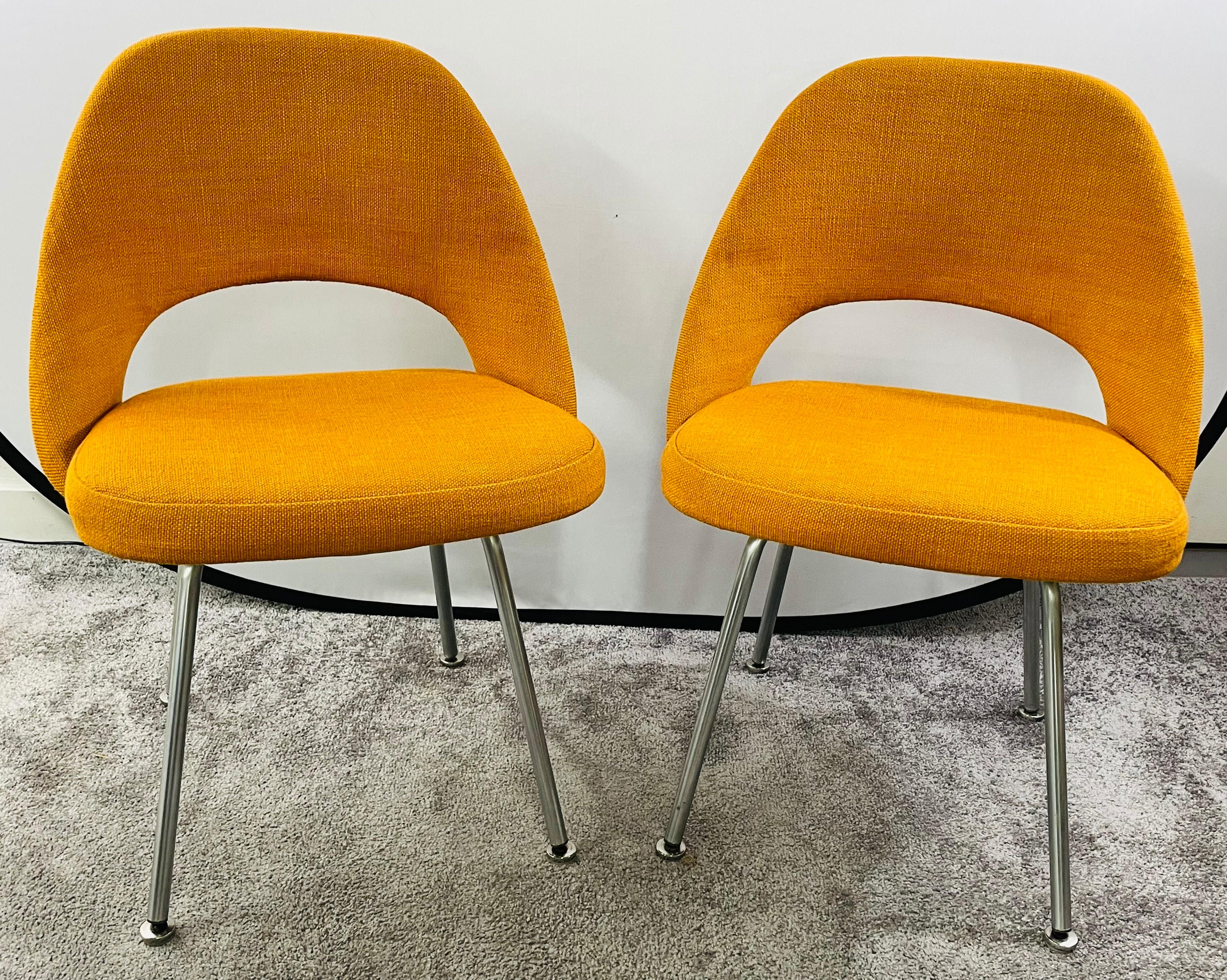A pair of Mid-Century Modern side chairs designed by Eero Sarrinen (Finnish/American, 1910-1961) for Knoll Associates, USA. The chairs are finely upholstered in a stylish turmeric orange tone. The chairs are marked with the manufacturer label
