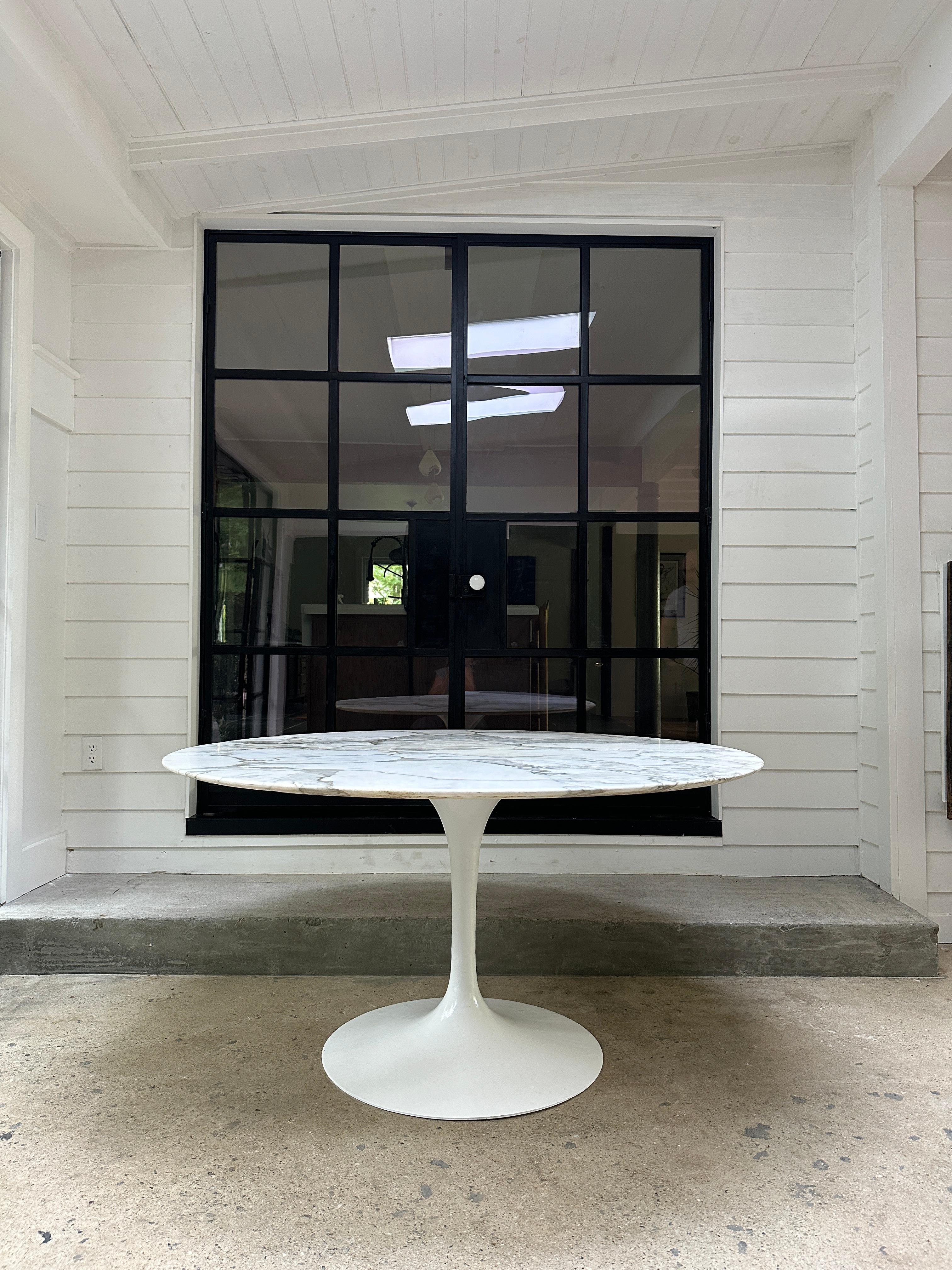 Mid Century 1950s Tulip dining table by Finish designer Eero Saarinen for Knoll International. The table has a beautiful Calacatta marble top and aluminum base, marked. 

54”Diameter x 28”H