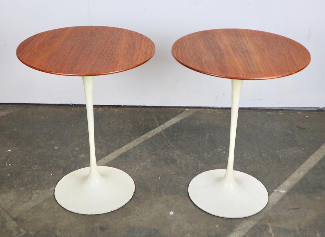 Gorgeous matches walnut top side tables designed by the legendary Eero Saarinen. This rare pair features the smaller 16” diameter tops. Both retain original Knoll bow tie labels under the tops and the original pint to the bases. Tops lightly touched